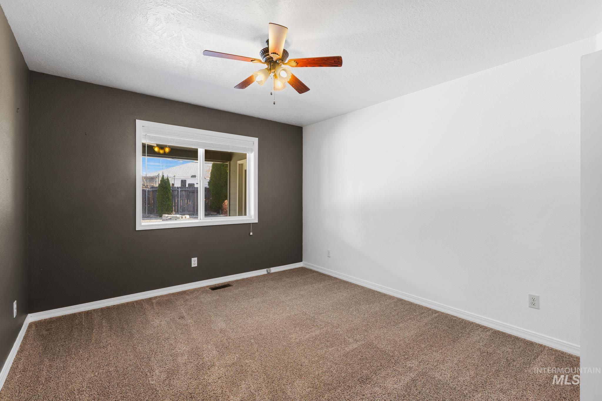 Bedroom featuring carpet floors, a ceiling fan, and a textured ceiling
