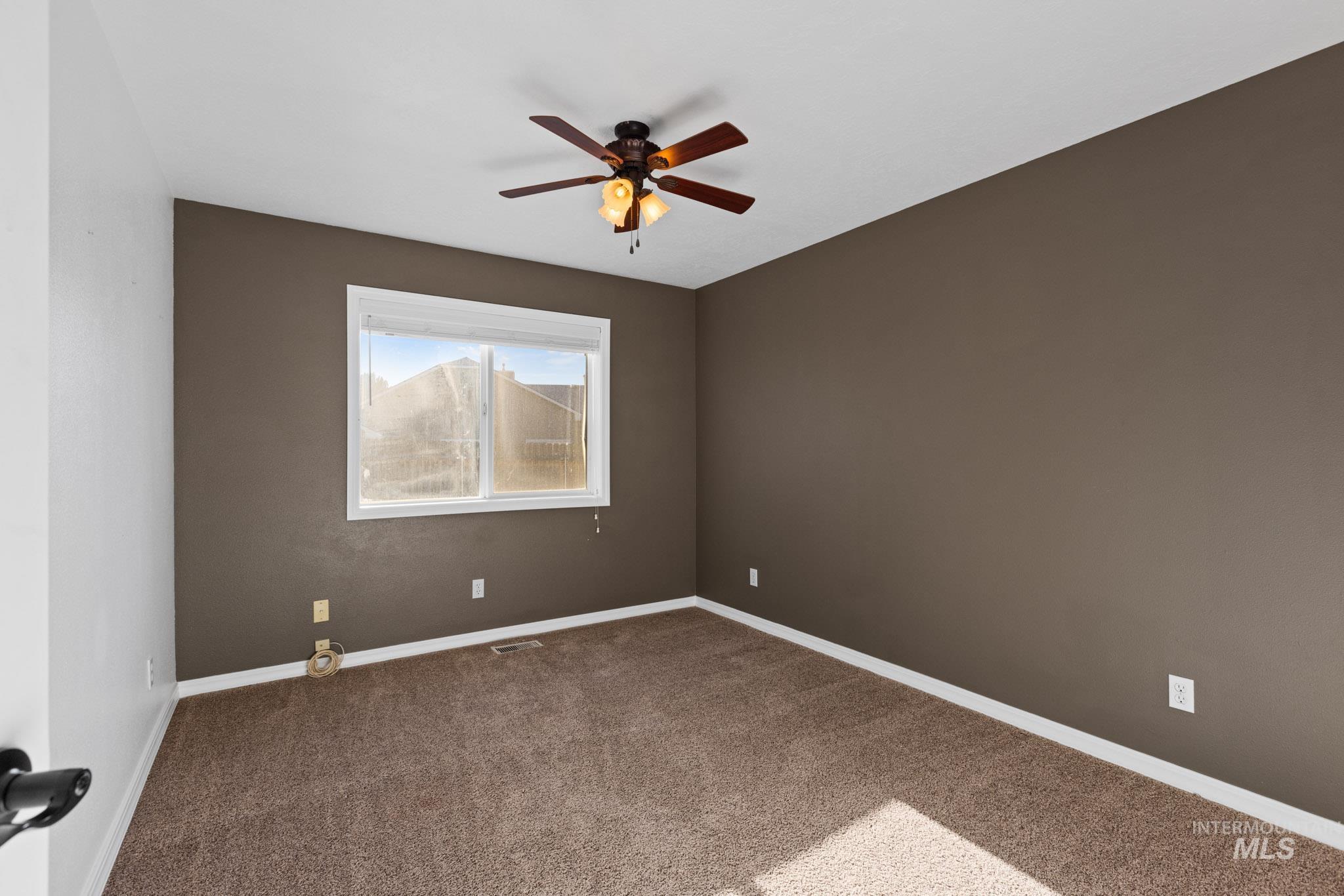 Carpeted bedroom featuring baseboards and a ceiling fan