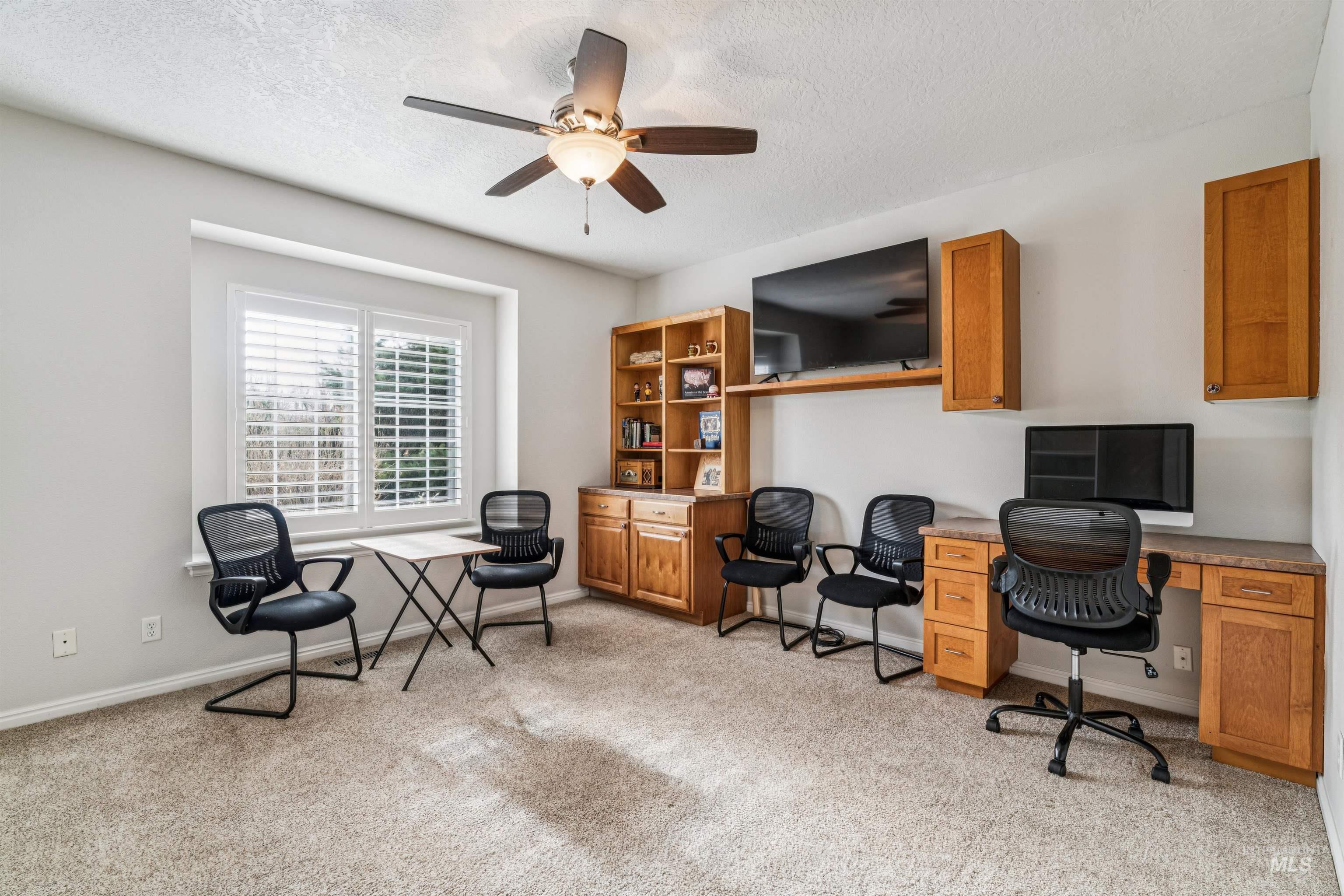 Office with light colored carpet, a textured ceiling, and ceiling fan