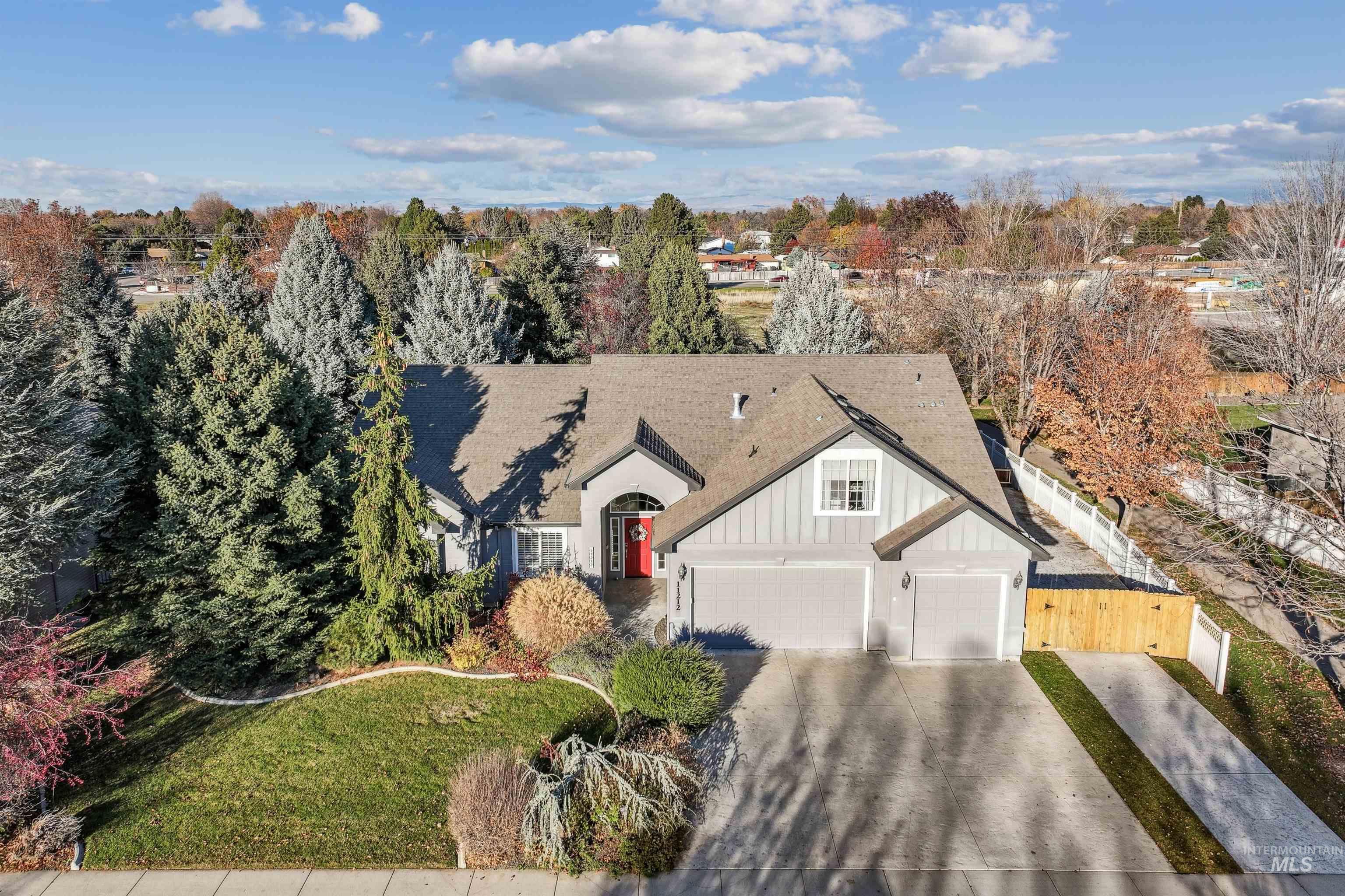 View of front of home featuring board and batten siding, concrete driveway, and roof with shingles