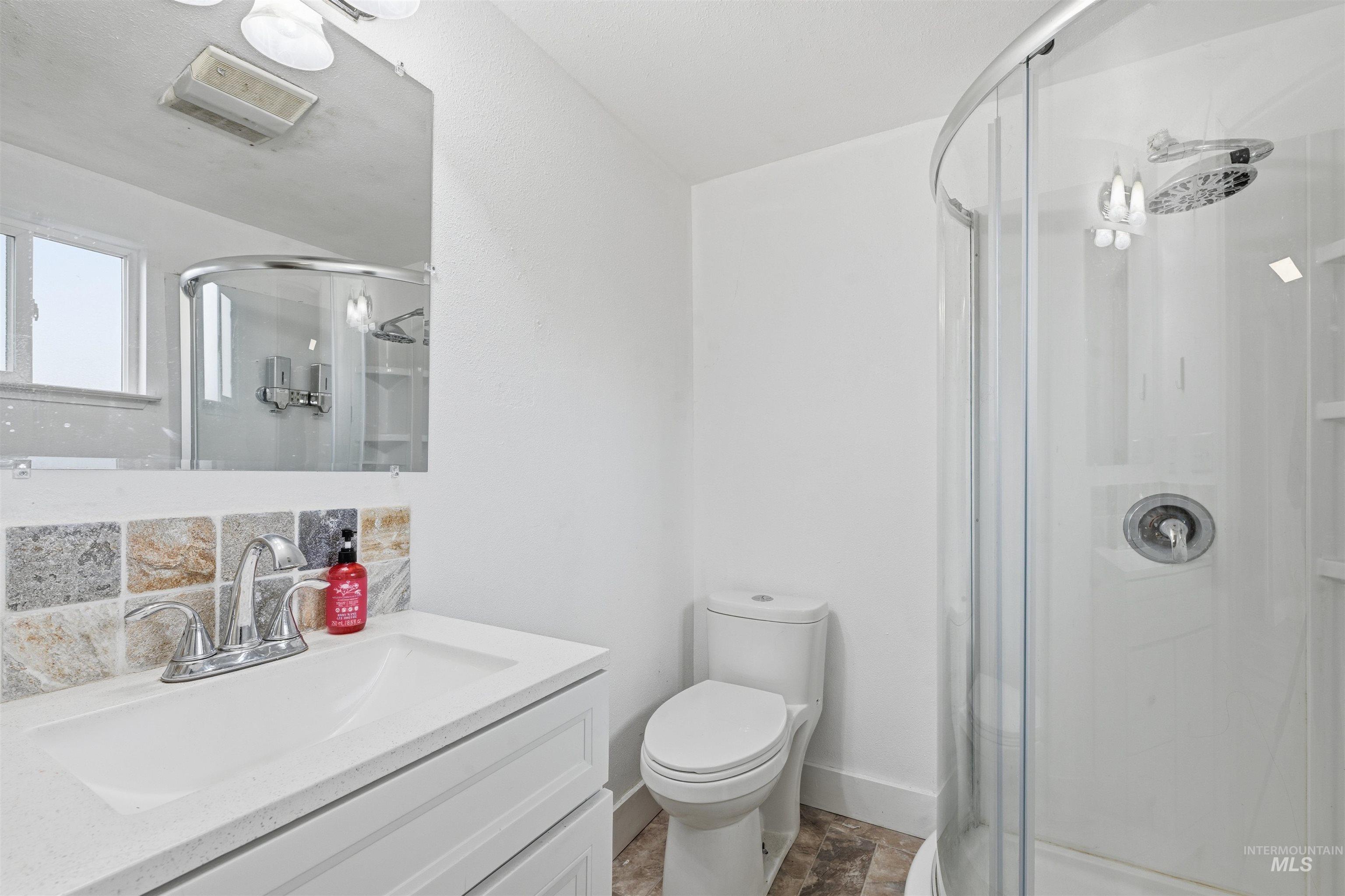 Full bathroom with vanity and a shower stall
