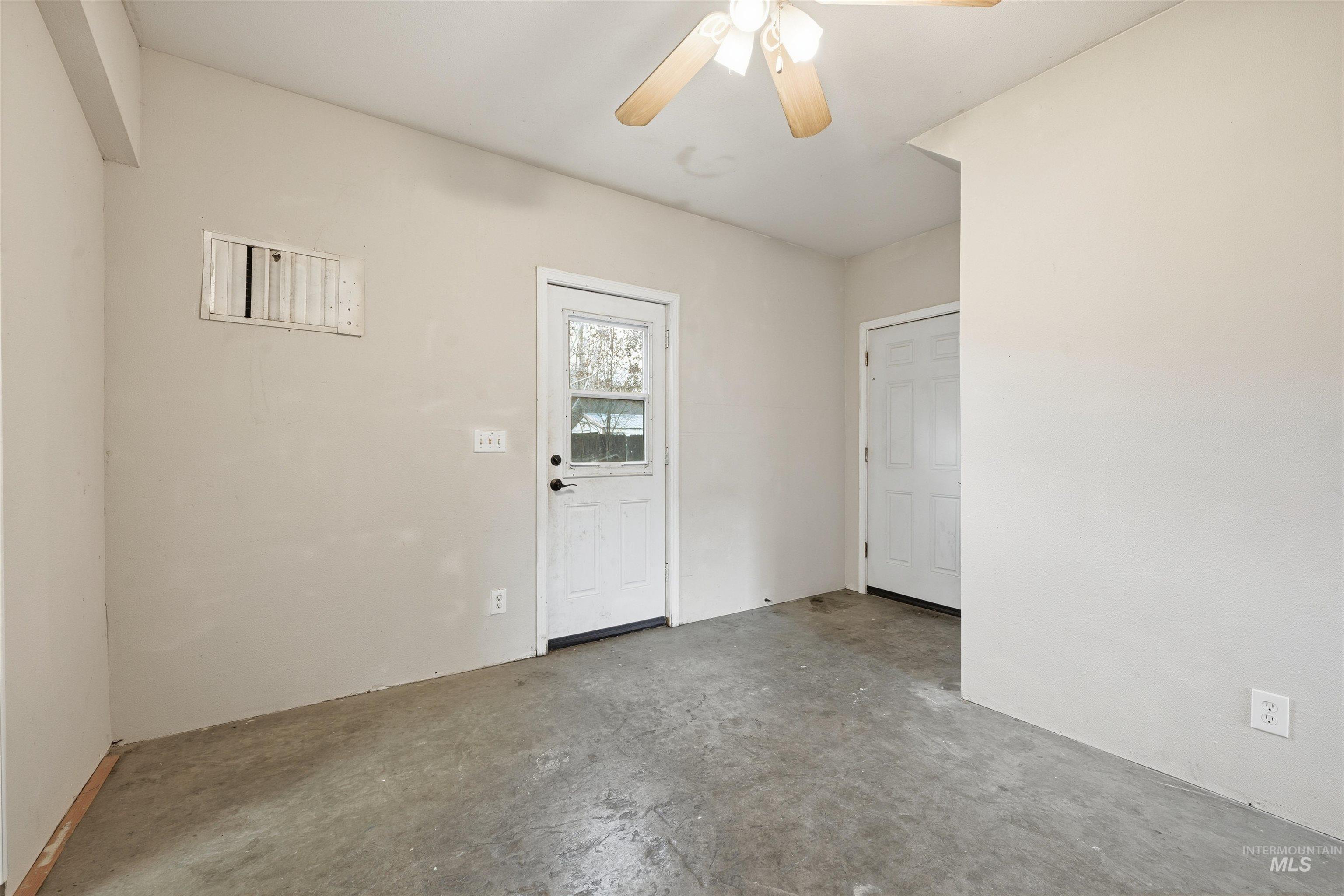 Spare room with concrete flooring and a ceiling fan