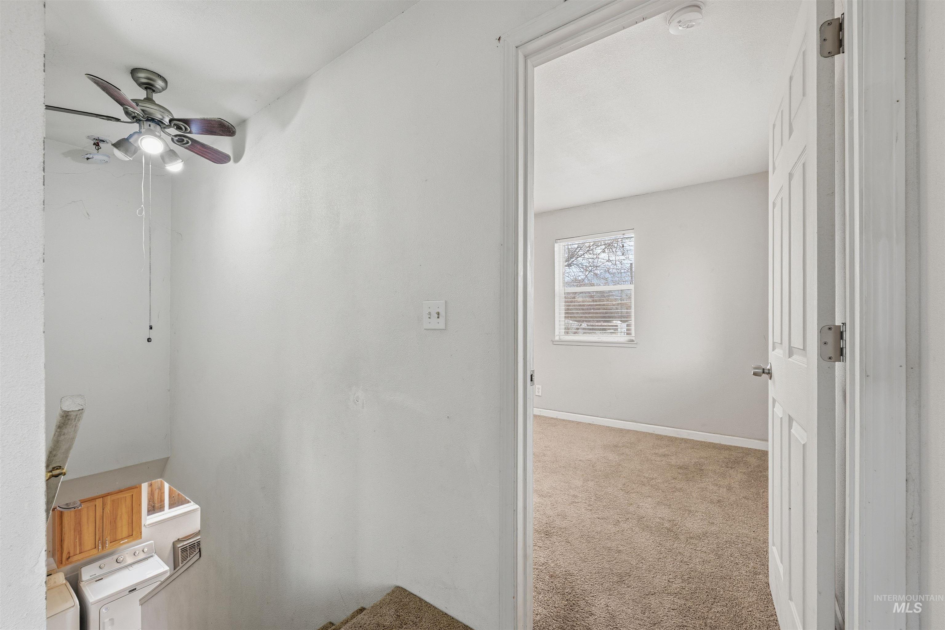 Hall featuring light colored carpet and an upstairs landing
