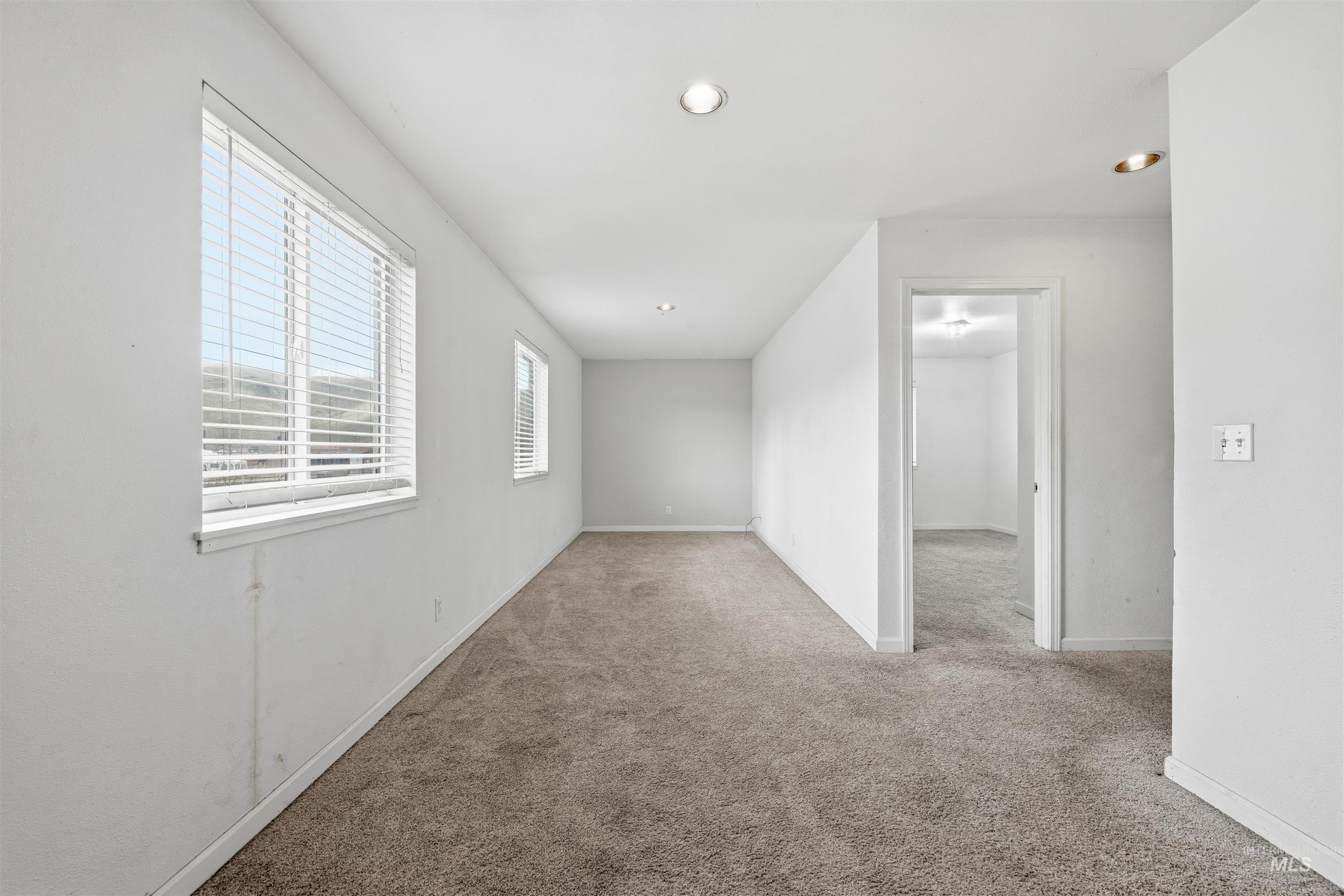 Carpeted spare room with recessed lighting and baseboards