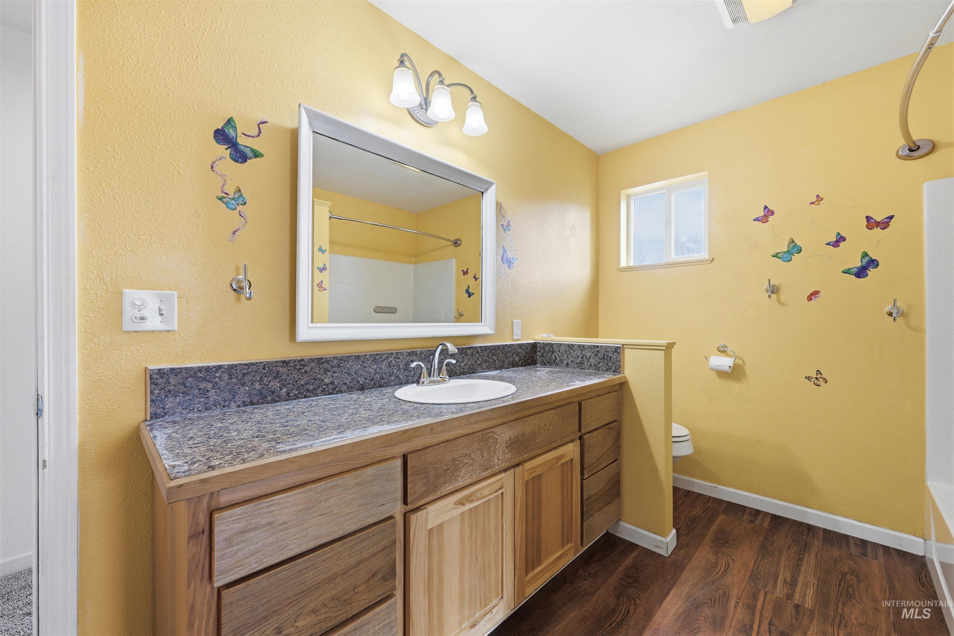 Full bath featuring vanity, shower / bath combination, and dark wood finished floors