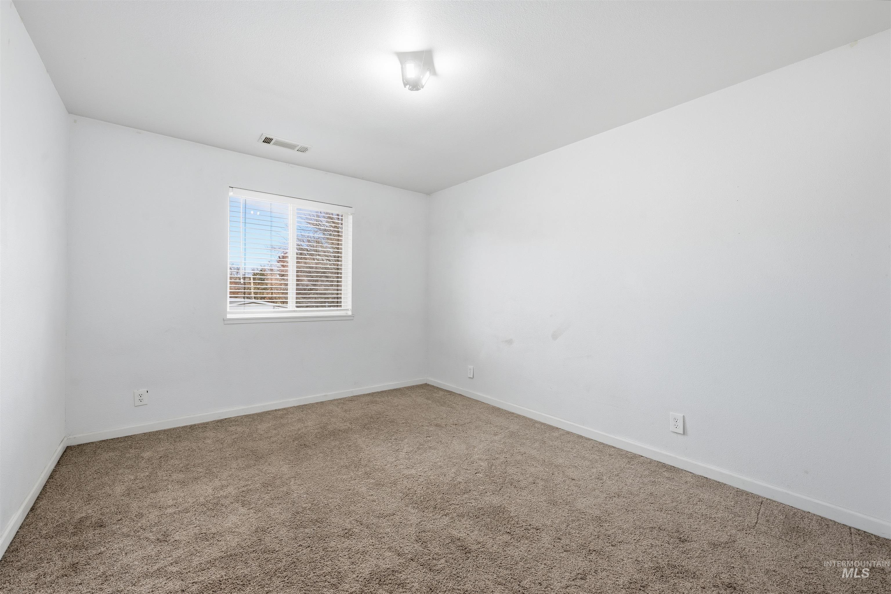 Spare room featuring carpet floors and baseboards