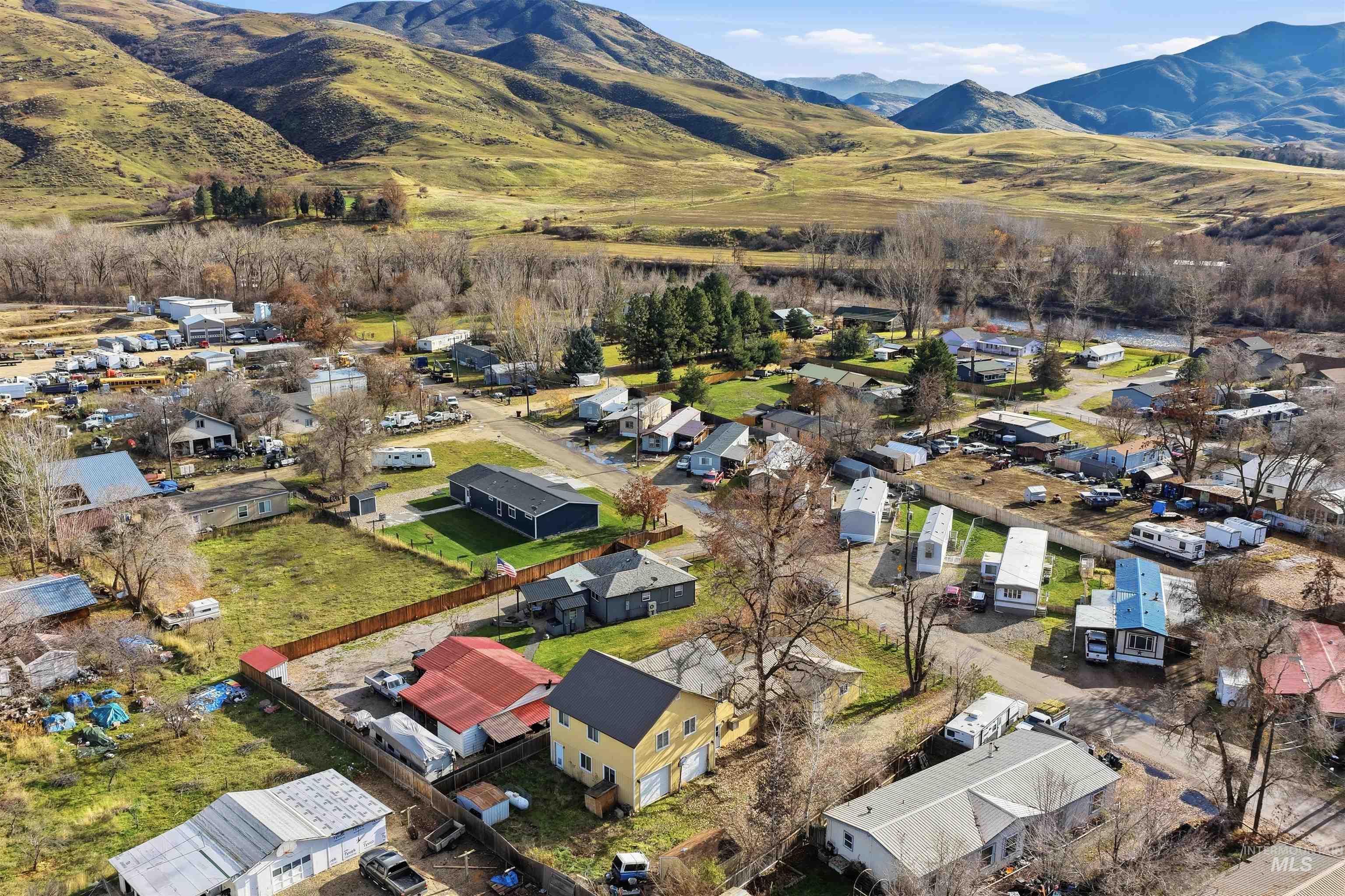 Aerial view of property and surrounding area with a mountainous background and nearby suburban area