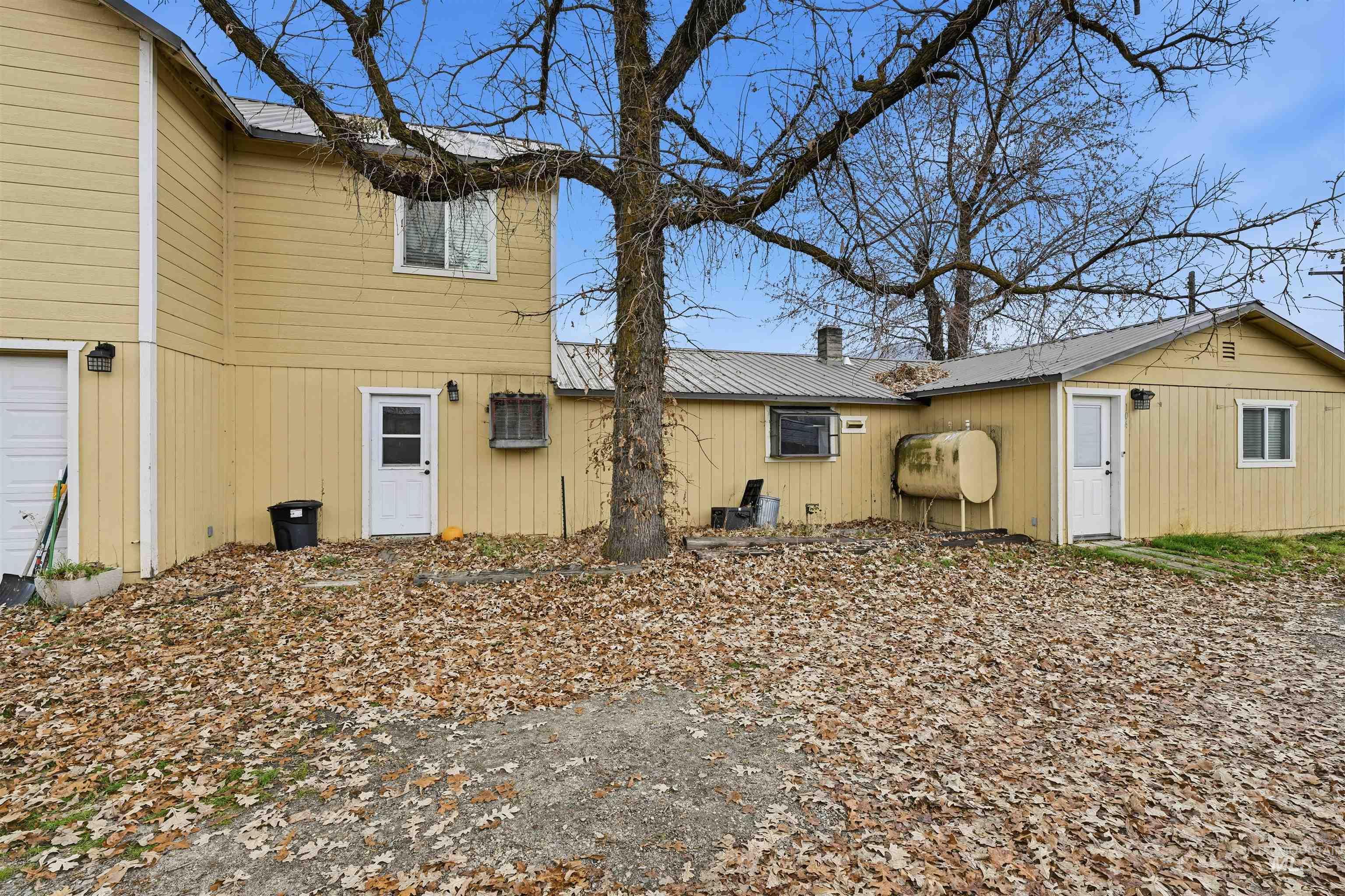 View of home's exterior with heating fuel, a metal roof, a chimney, and a garage