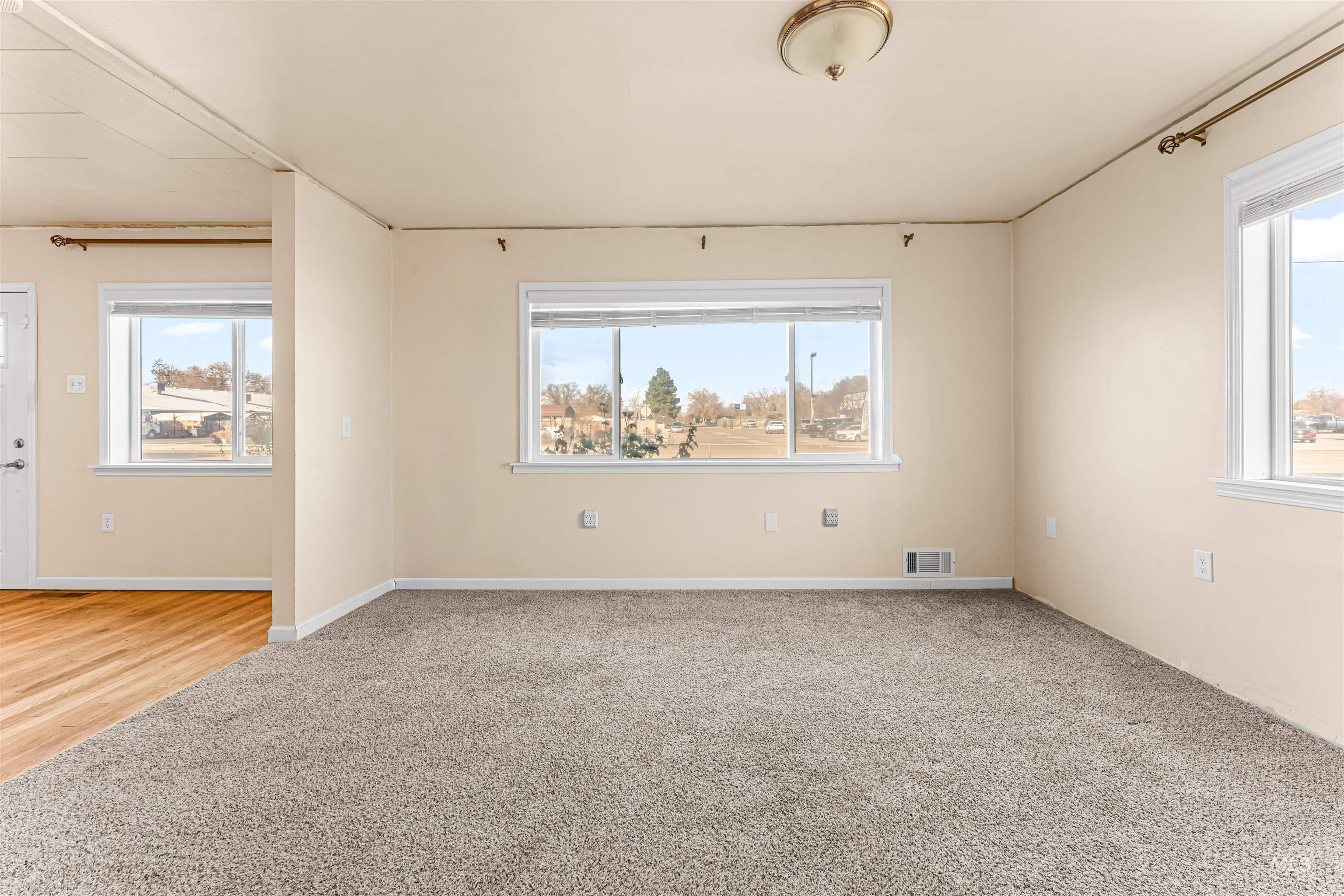 Spare room with light colored carpet and plenty of natural light