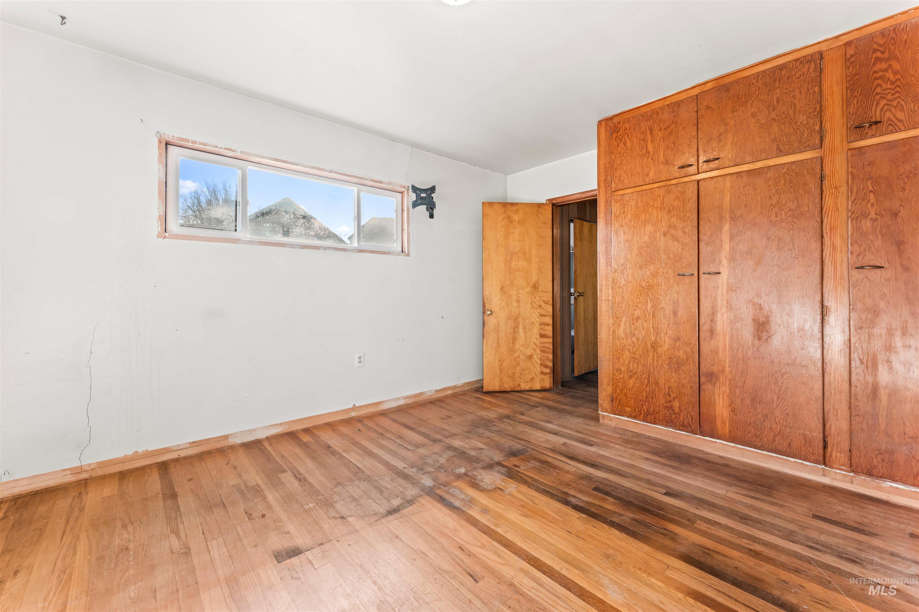 Unfurnished bedroom with a closet and hardwood / wood-style floors