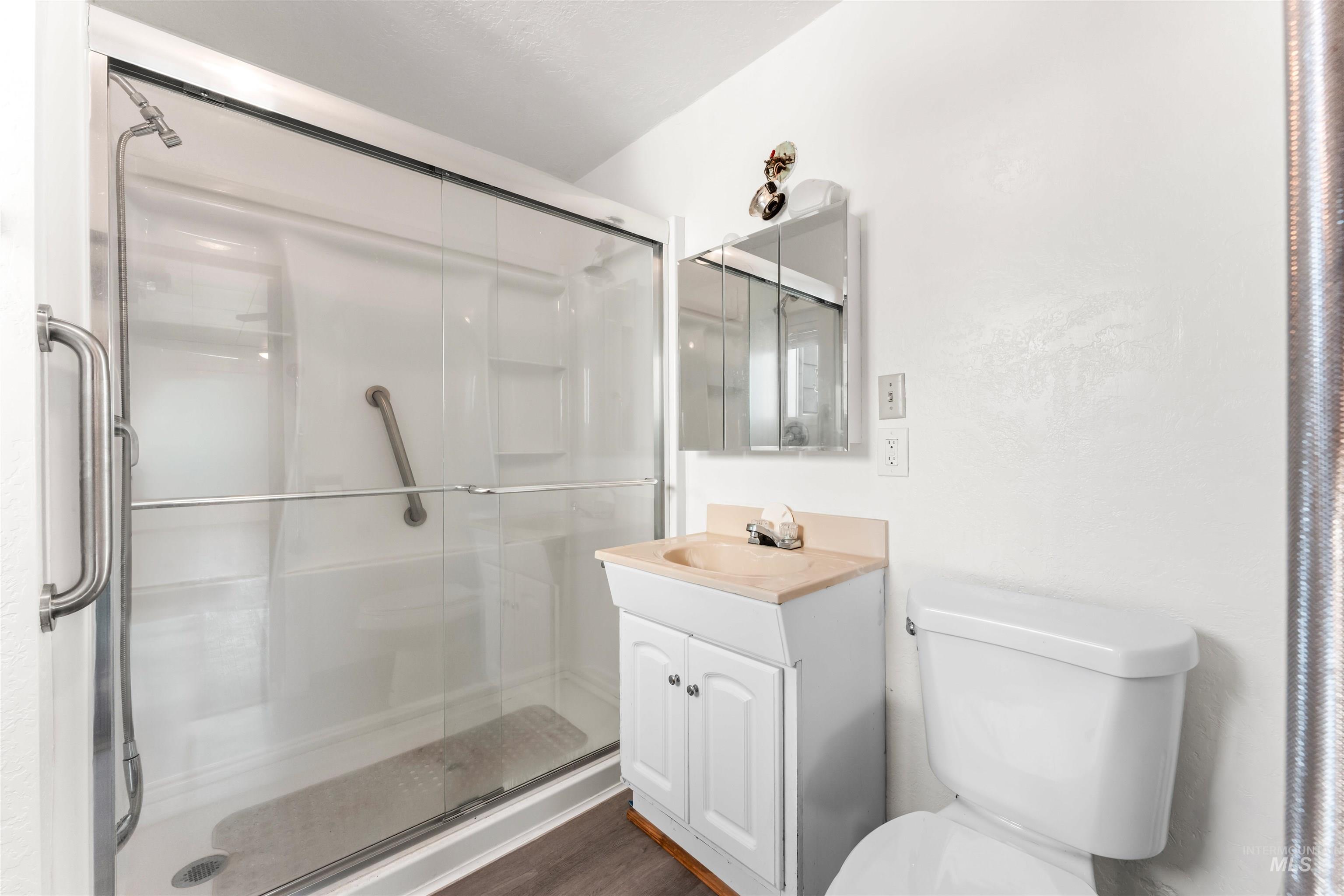 Full bath with a shower stall and vanity