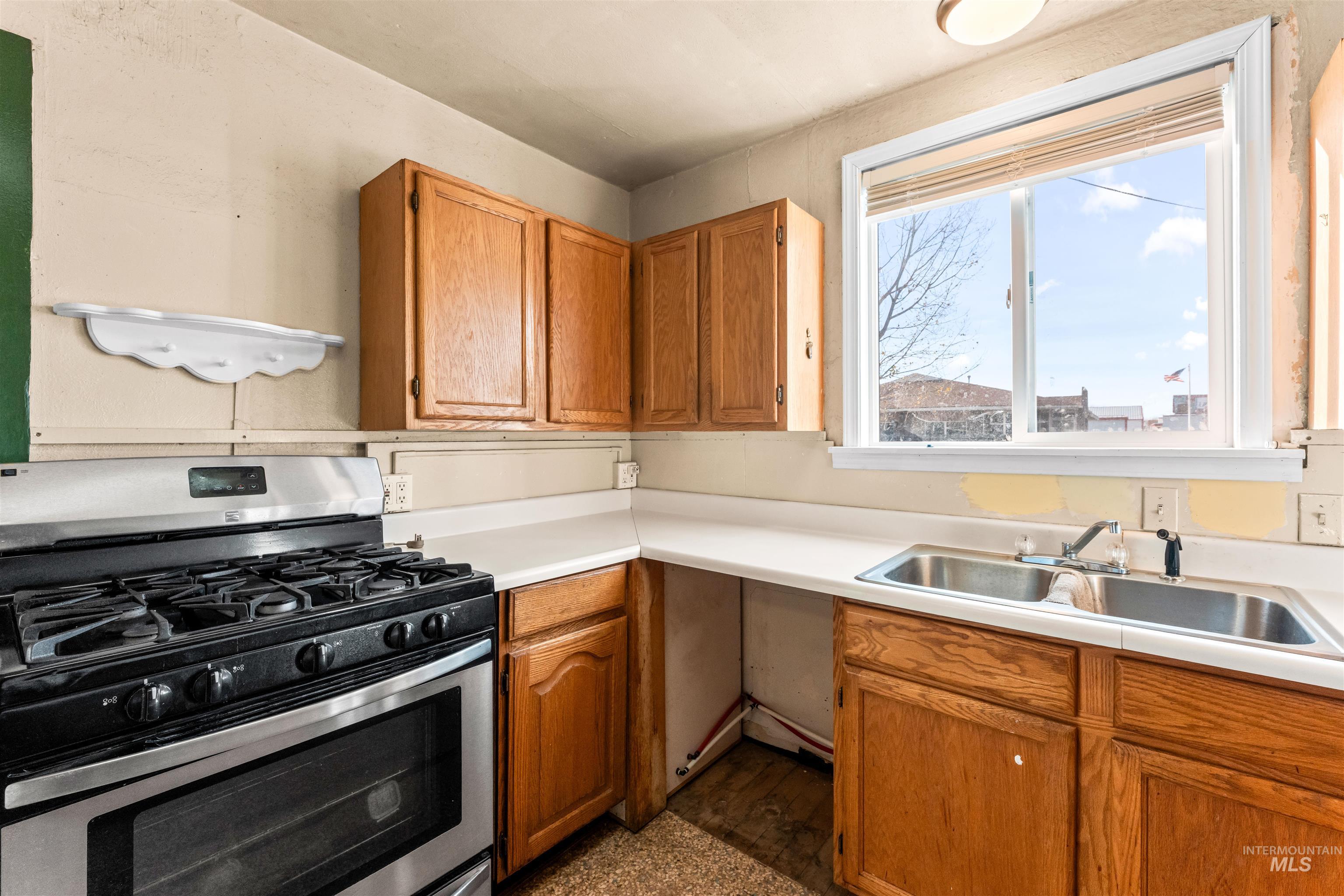 Kitchen featuring gas stove, brown cabinets, and light countertops