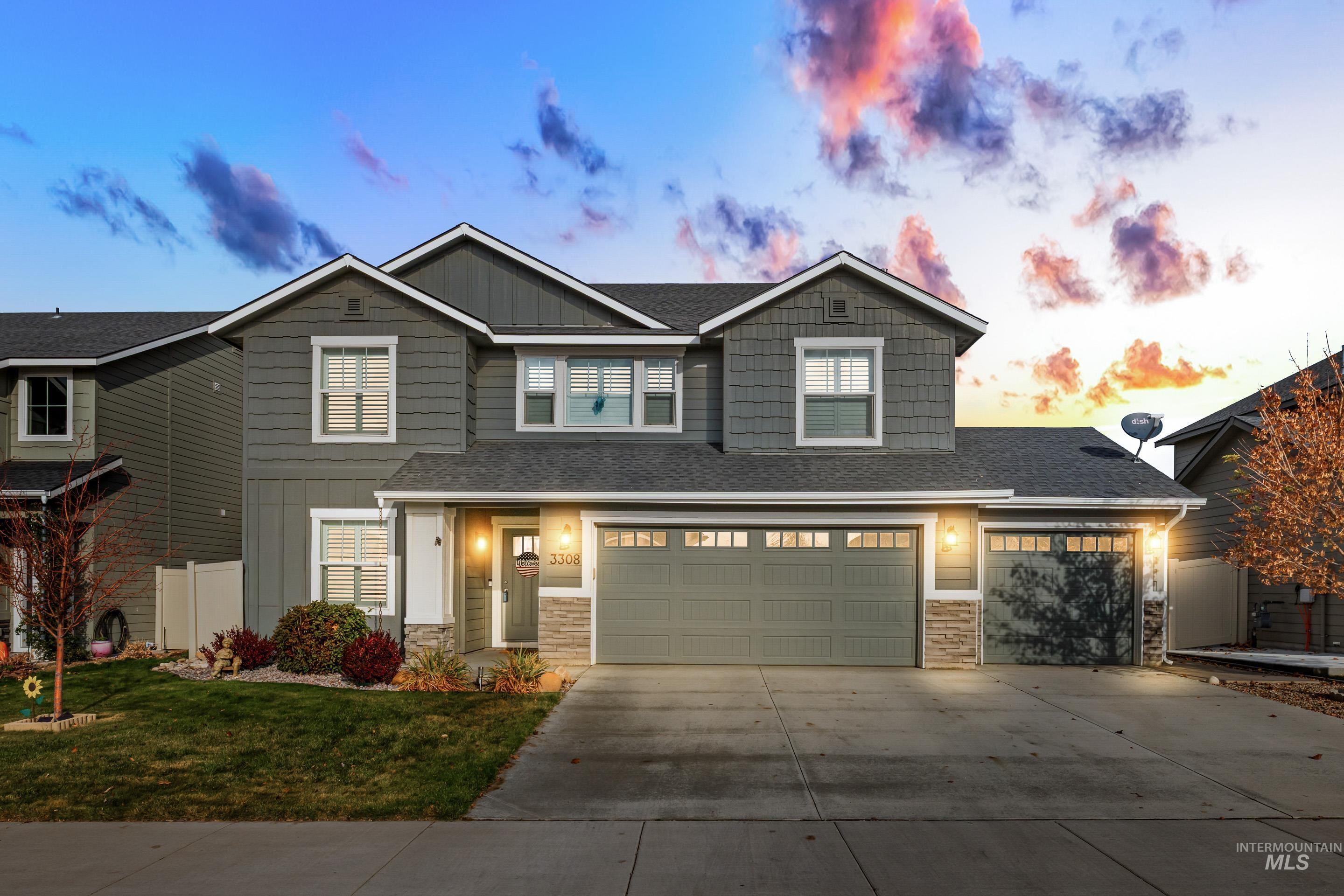 Craftsman-style house featuring board and batten siding, stone siding, concrete driveway, and a garage