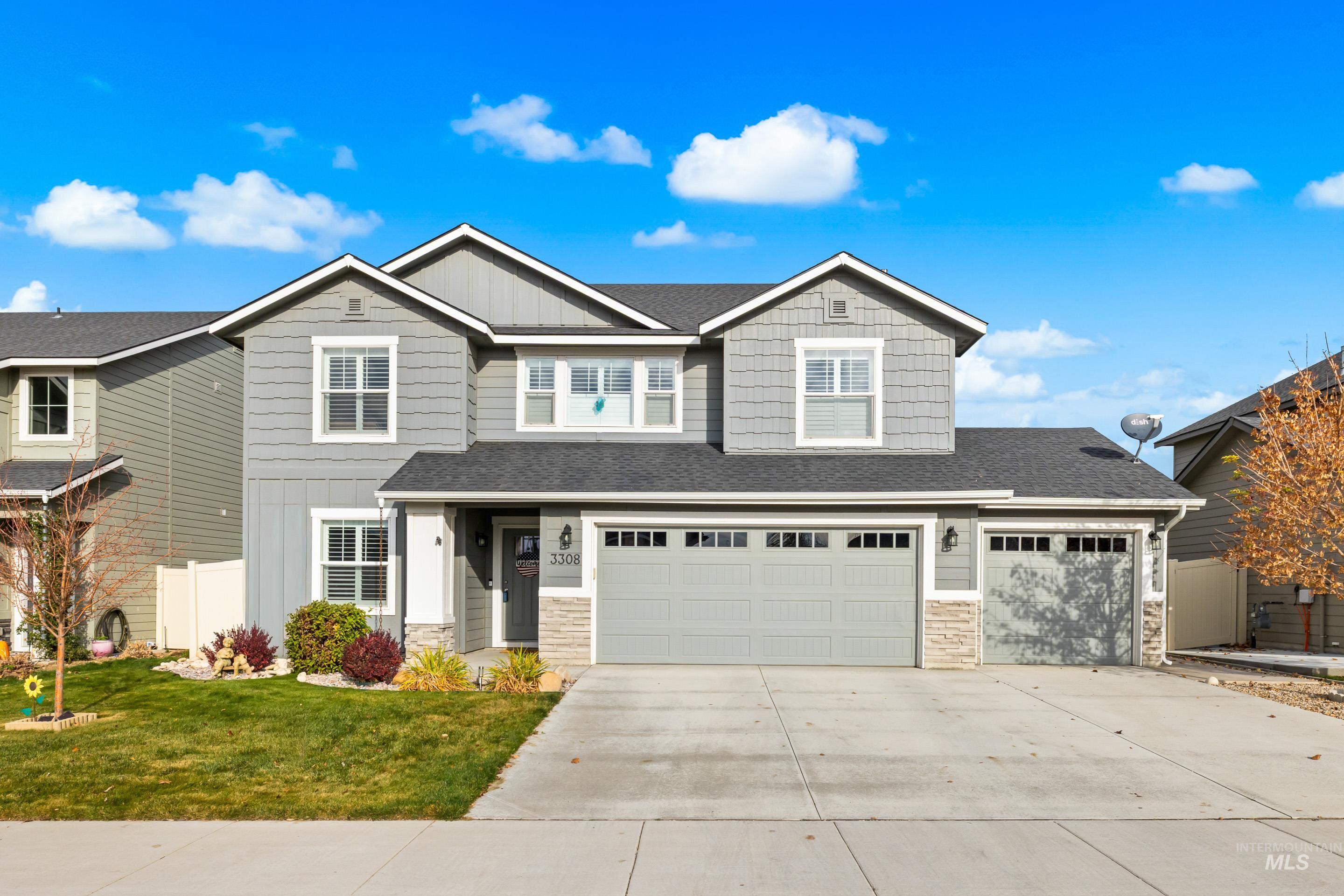 Craftsman house featuring board and batten siding, stone siding, concrete driveway, and roof with shingles