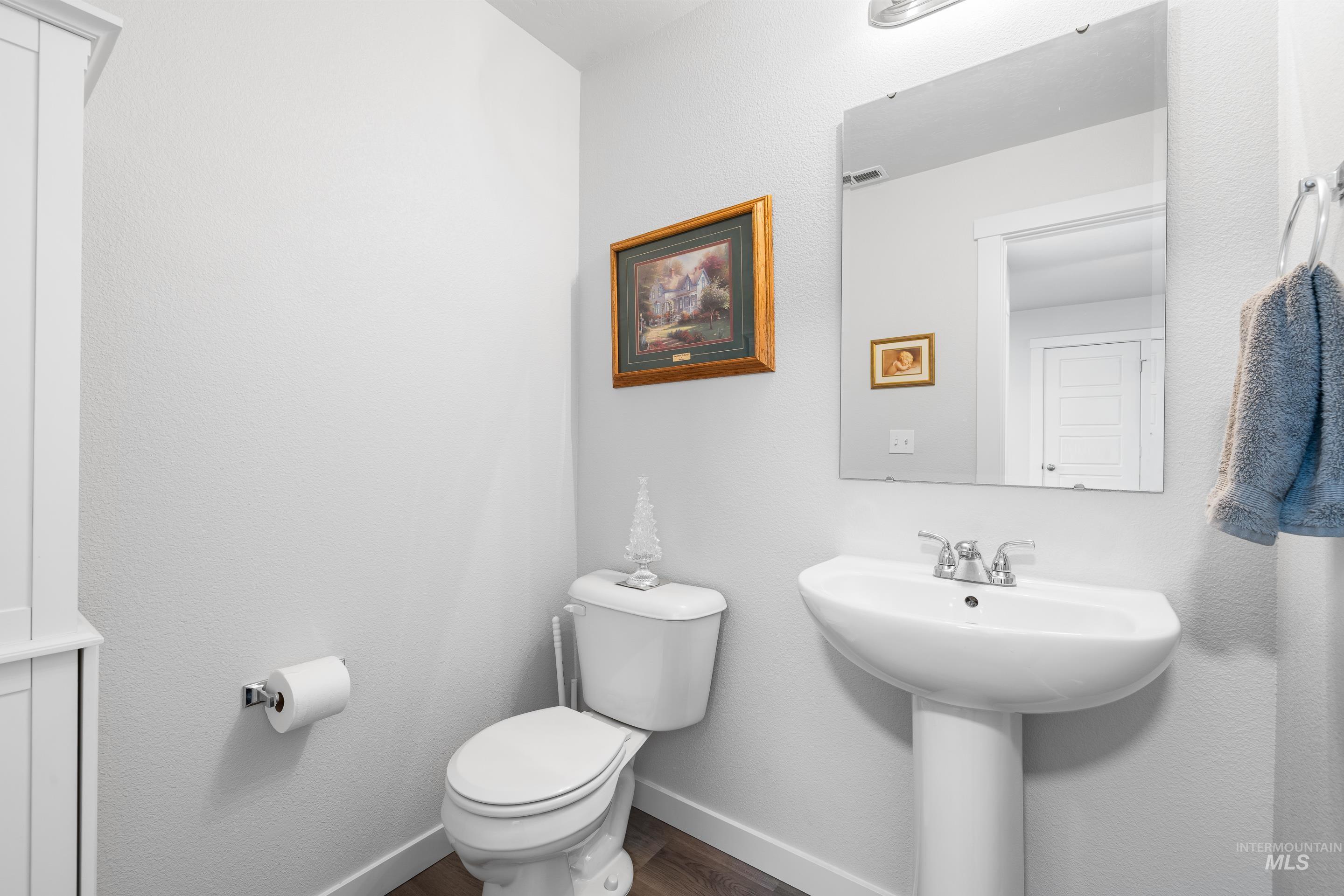 Half bathroom featuring baseboards and dark wood-type flooring