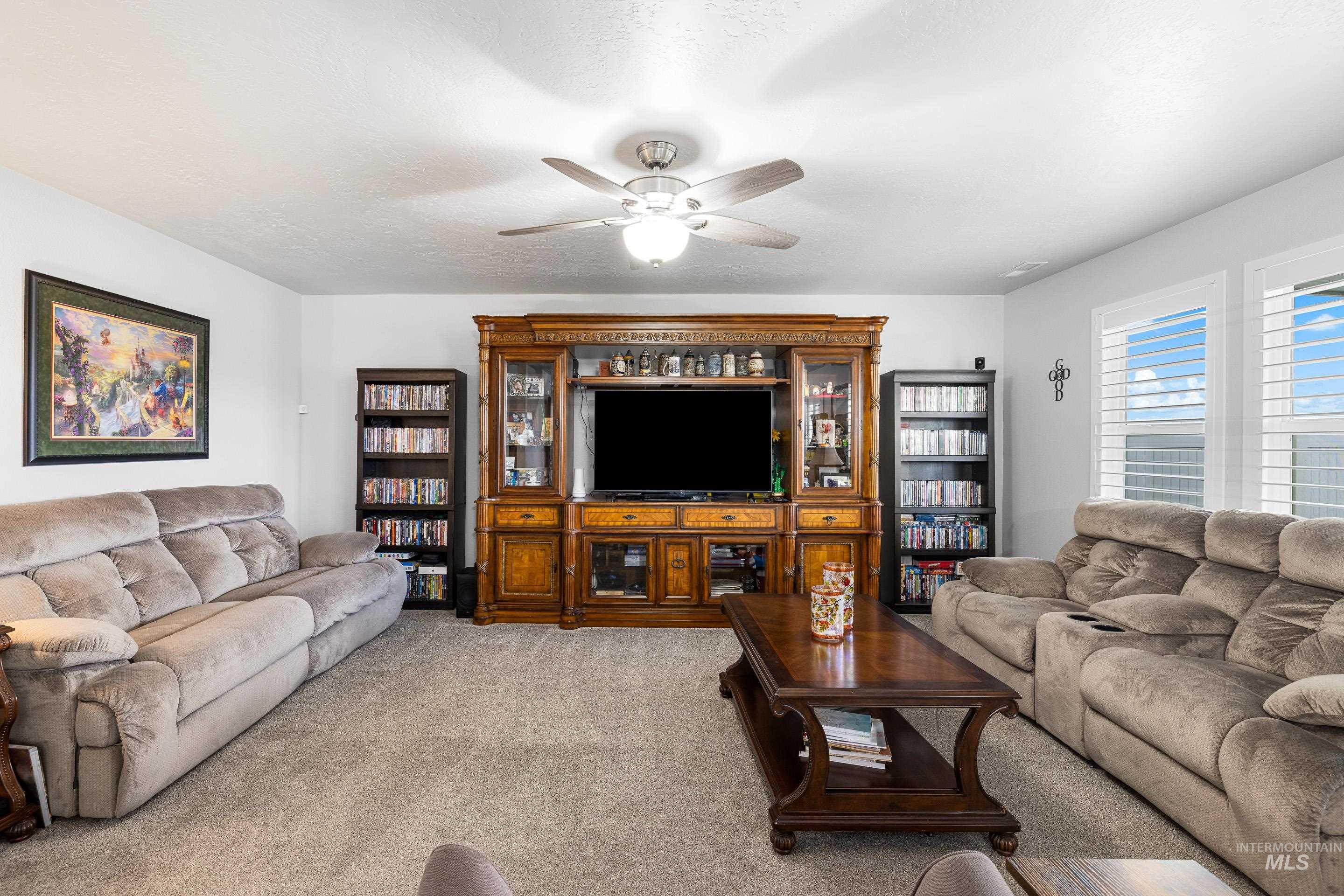 Living room featuring a ceiling fan and light colored carpet