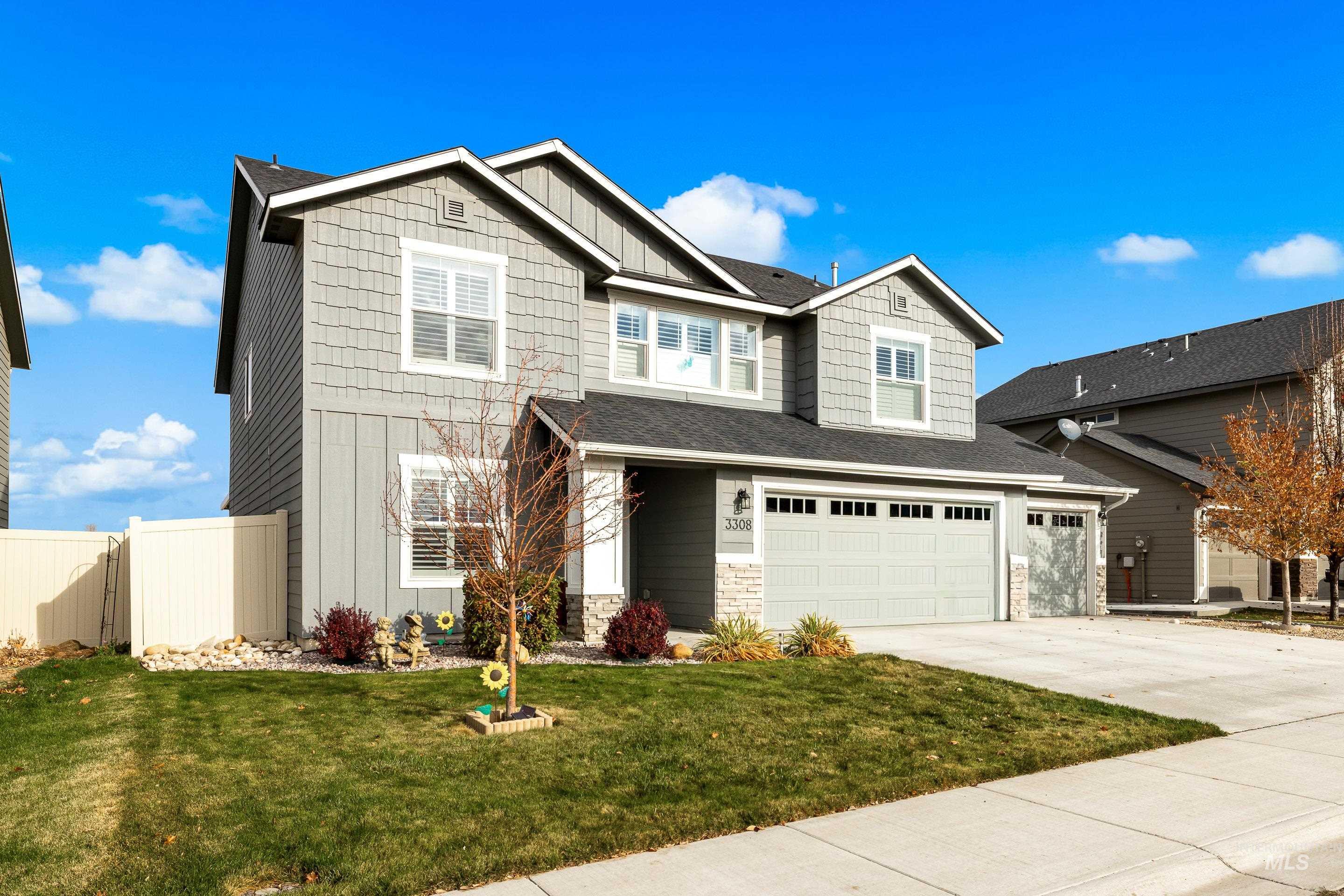Craftsman-style home featuring stone siding, board and batten siding, driveway, a garage, and roof with shingles