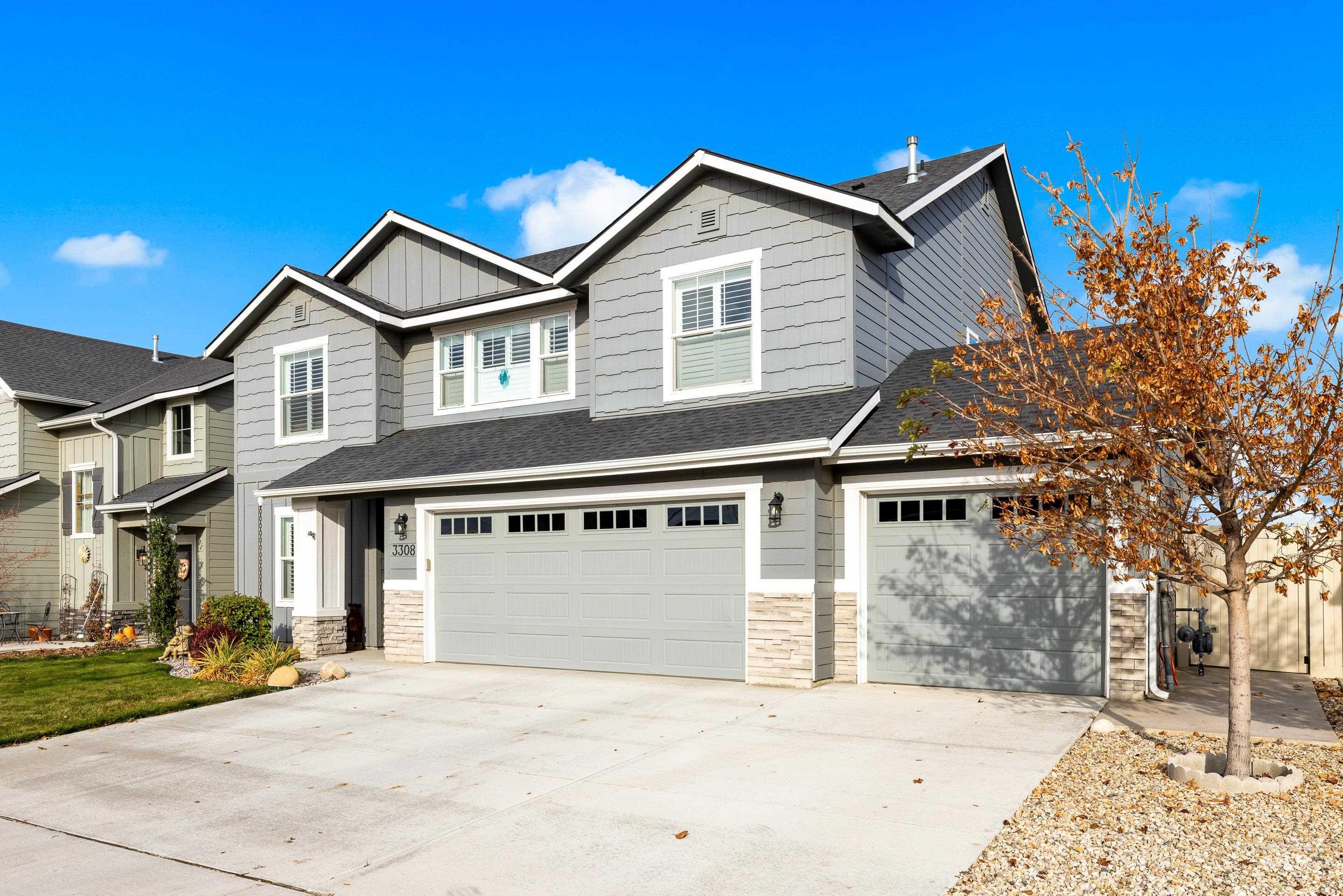 Craftsman house with stone siding, driveway, and a garage