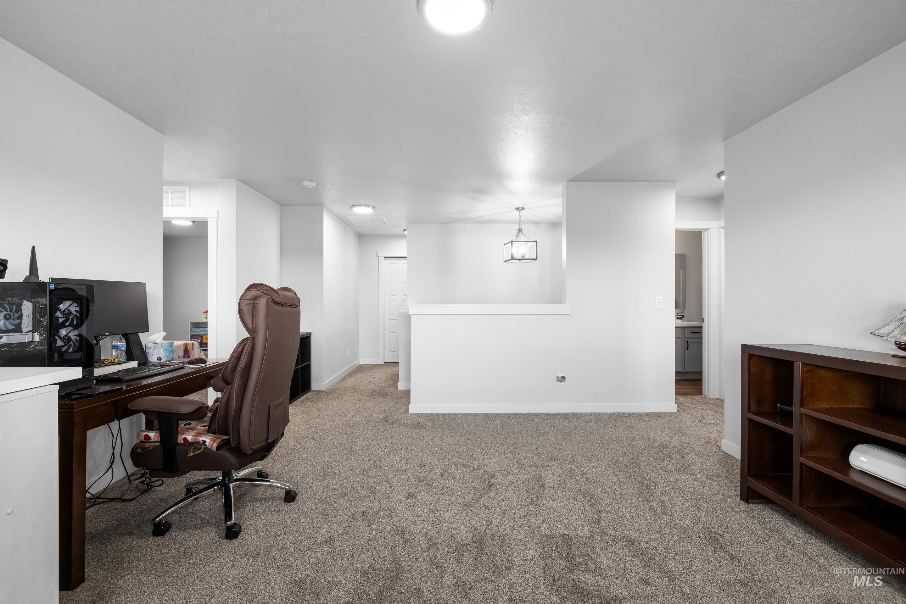 Office area with light colored carpet and baseboards