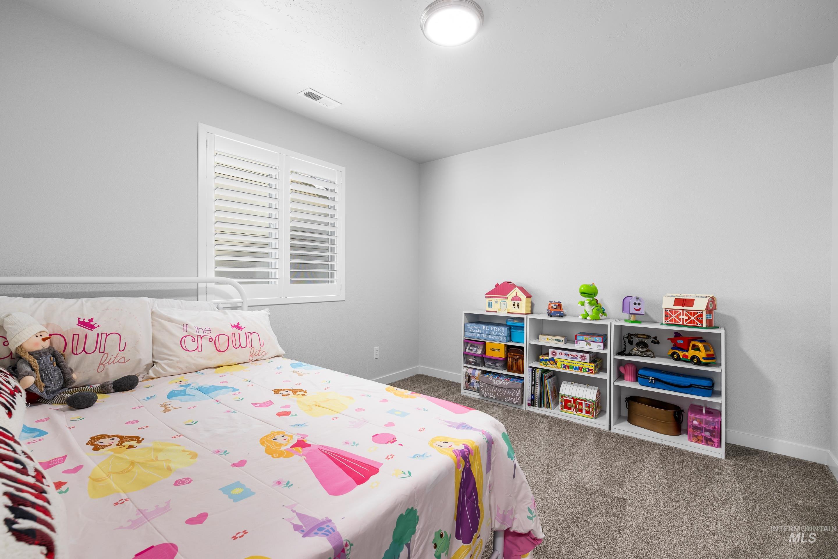 Bedroom featuring dark carpet and baseboards