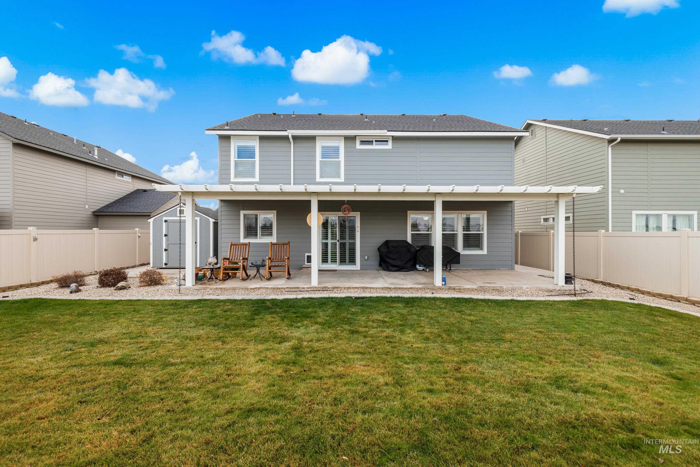Back of property featuring a patio, a storage unit, and a fenced backyard