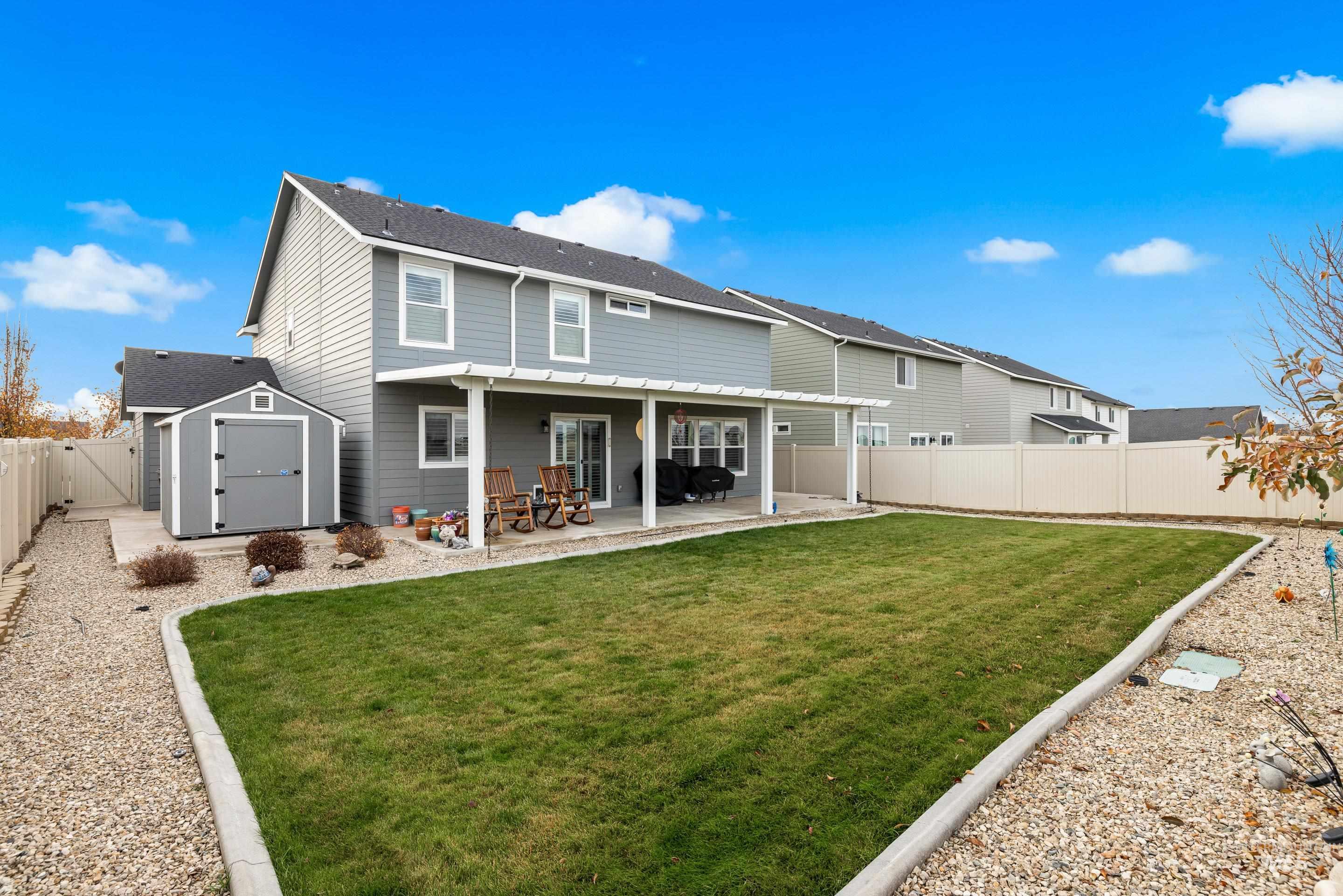 Back of property with a shed, a fenced backyard, and a patio