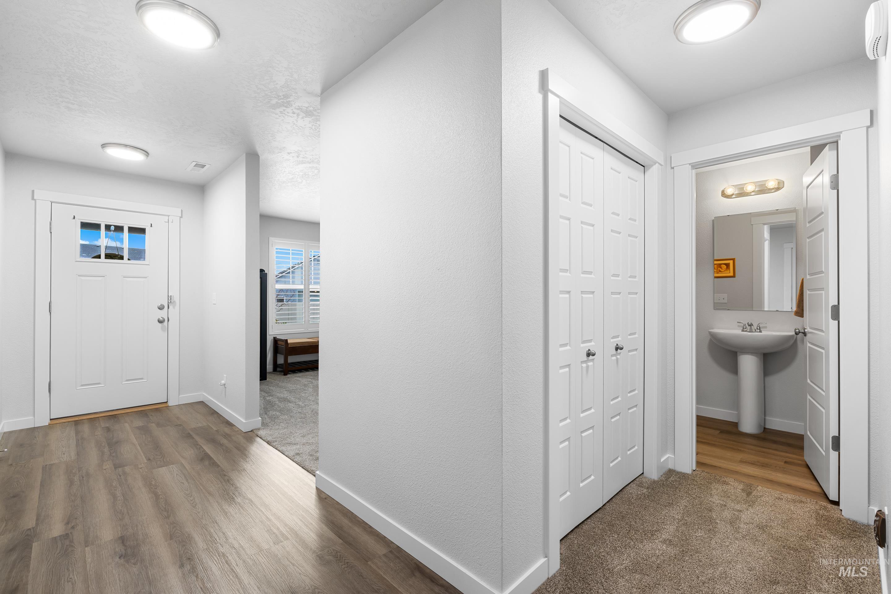 Foyer entrance featuring dark carpet and dark wood-style flooring