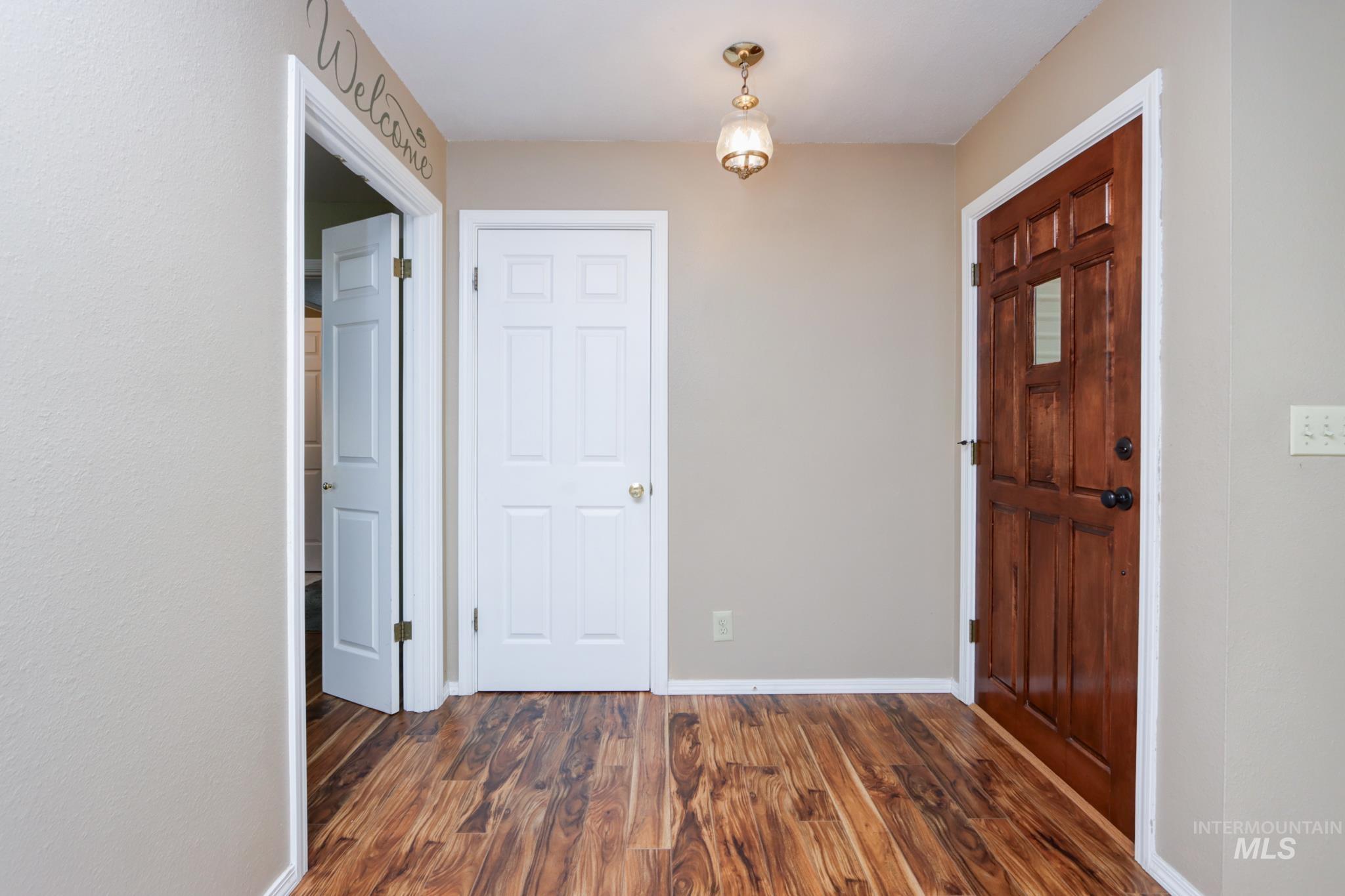Entrance foyer with dark wood-style floors and baseboards