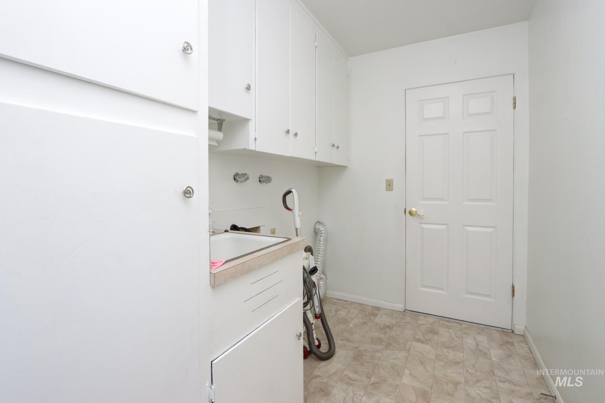 Laundry area with cabinet space and baseboards