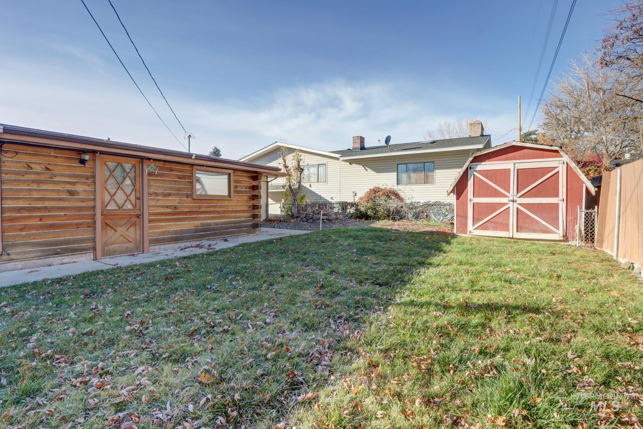 Back of property featuring a storage unit and log siding