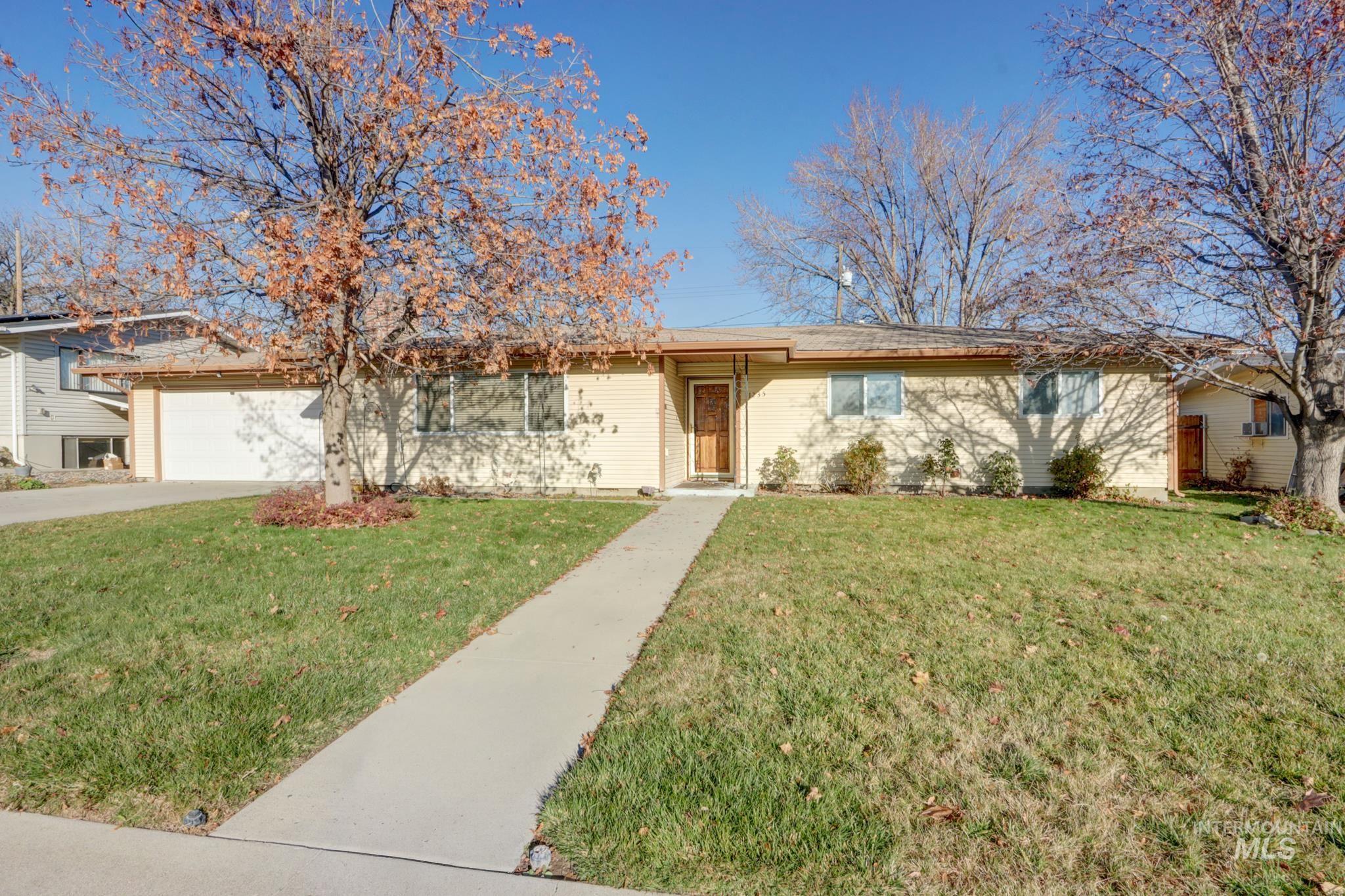 Single story home with a front yard, driveway, and an attached garage