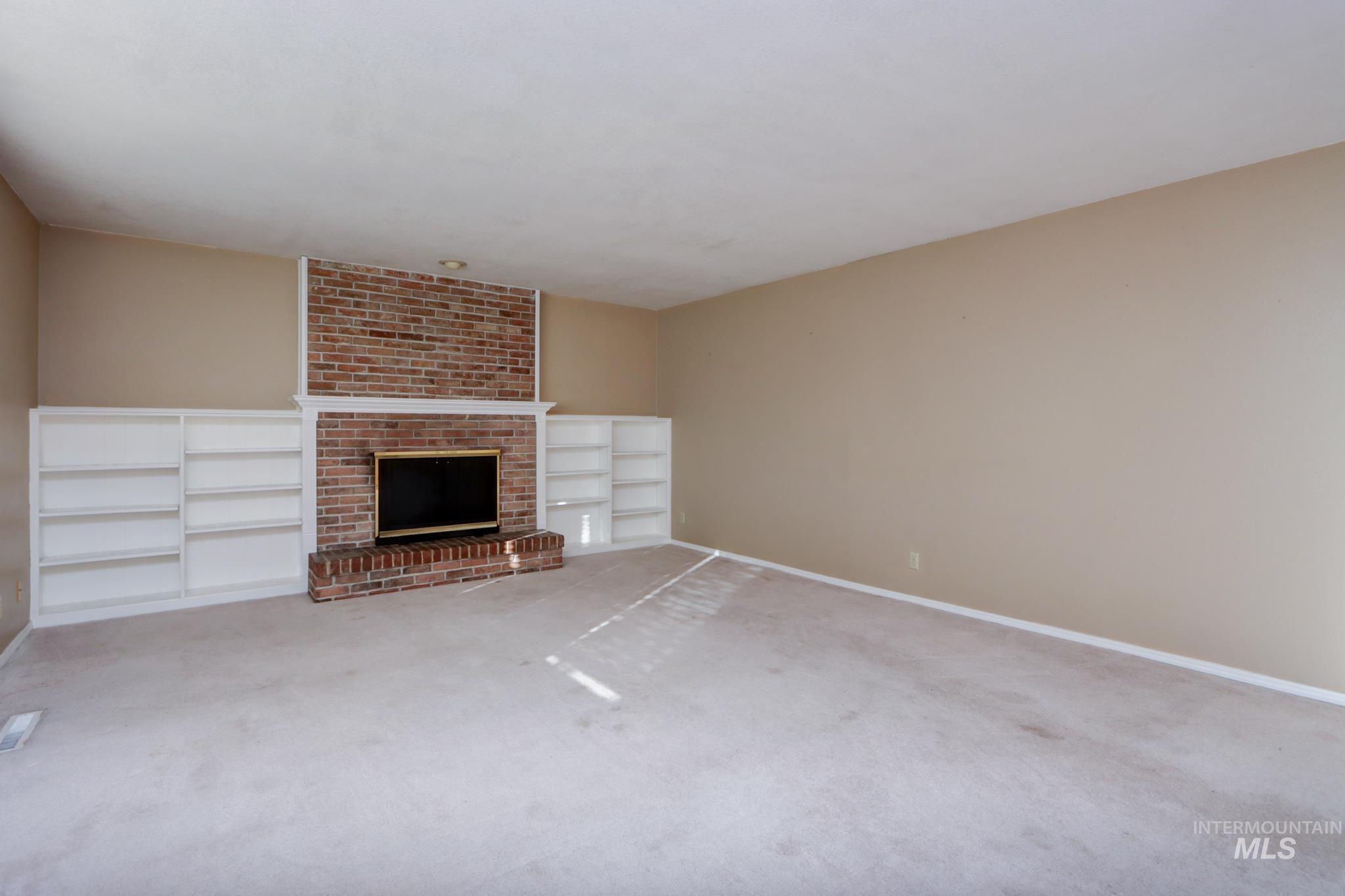 Unfurnished living room with a fireplace and carpet floors