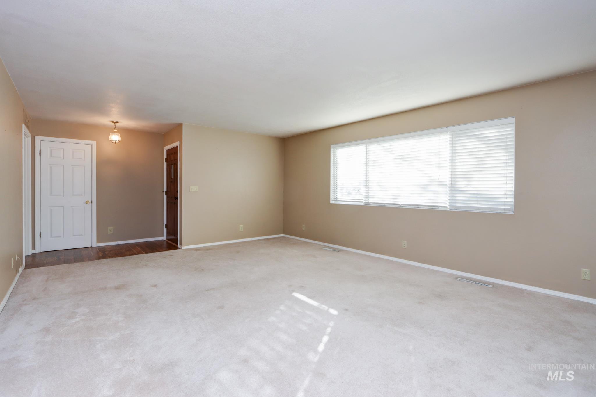 Carpeted empty room with baseboards
