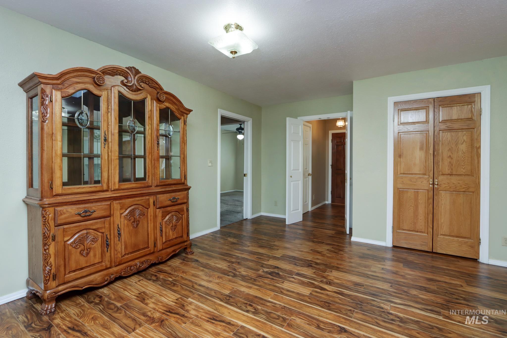 Unfurnished dining area featuring dark wood finished floors and a ceiling fan