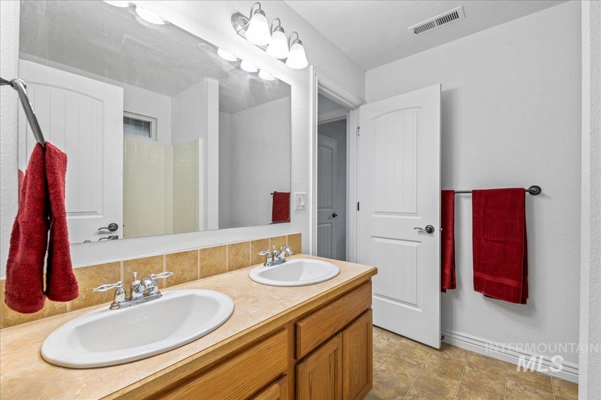 Bathroom featuring double vanity and baseboards