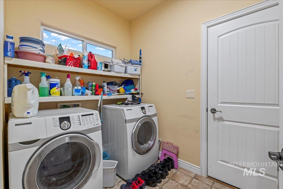 Laundry room with separate washer and dryer and baseboards