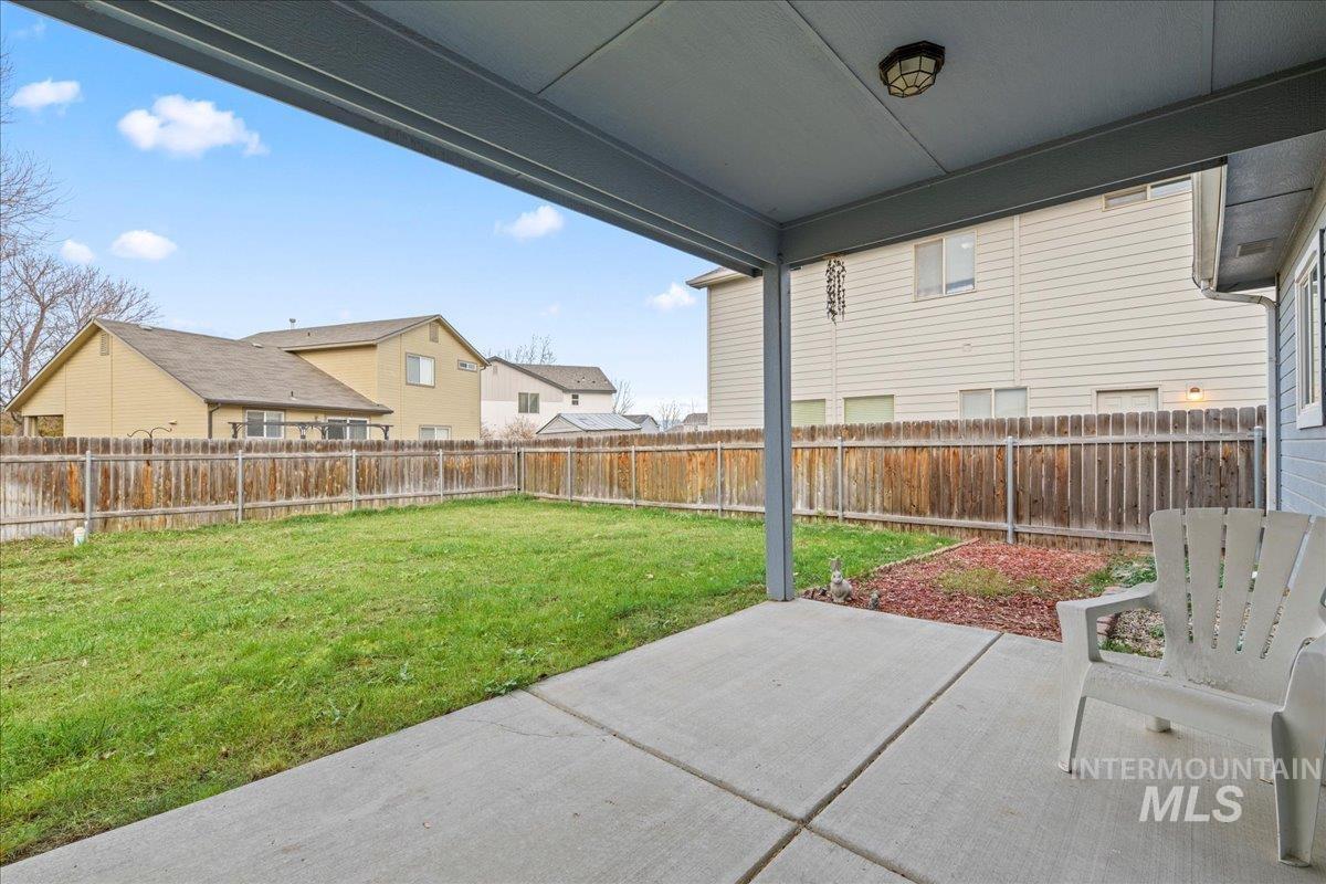 Fenced backyard featuring a patio and a residential view