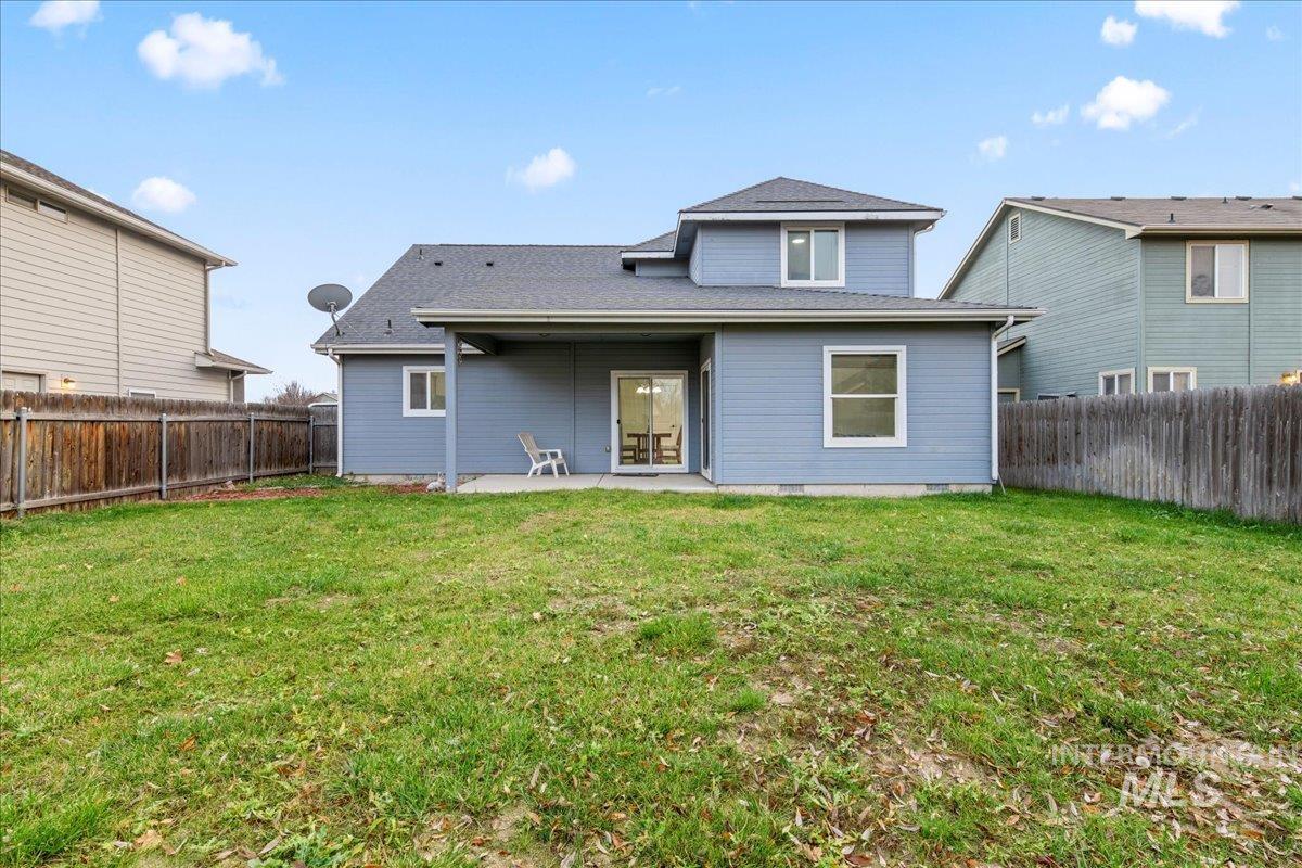 Back of property featuring a patio, a fenced backyard, and roof with shingles