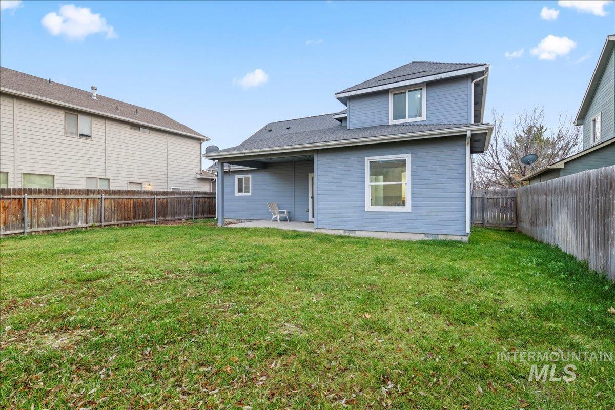Rear view of property with a patio area, a fenced backyard, and roof with shingles