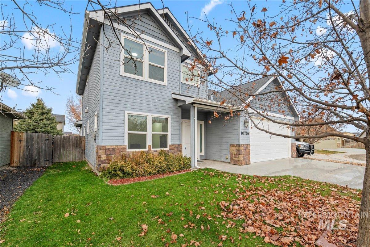 View of front of property with stone siding, driveway, and a garage