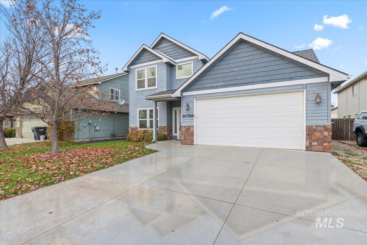 Craftsman-style home with stone siding, concrete driveway, and an attached garage