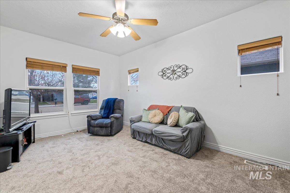 Living area featuring carpet and ceiling fan