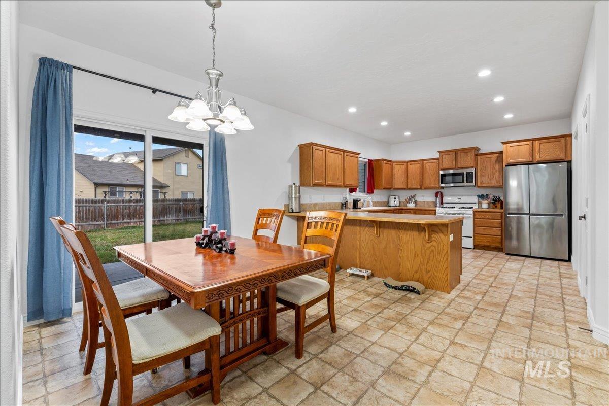Dining space featuring recessed lighting, stone finish floors, and a chandelier