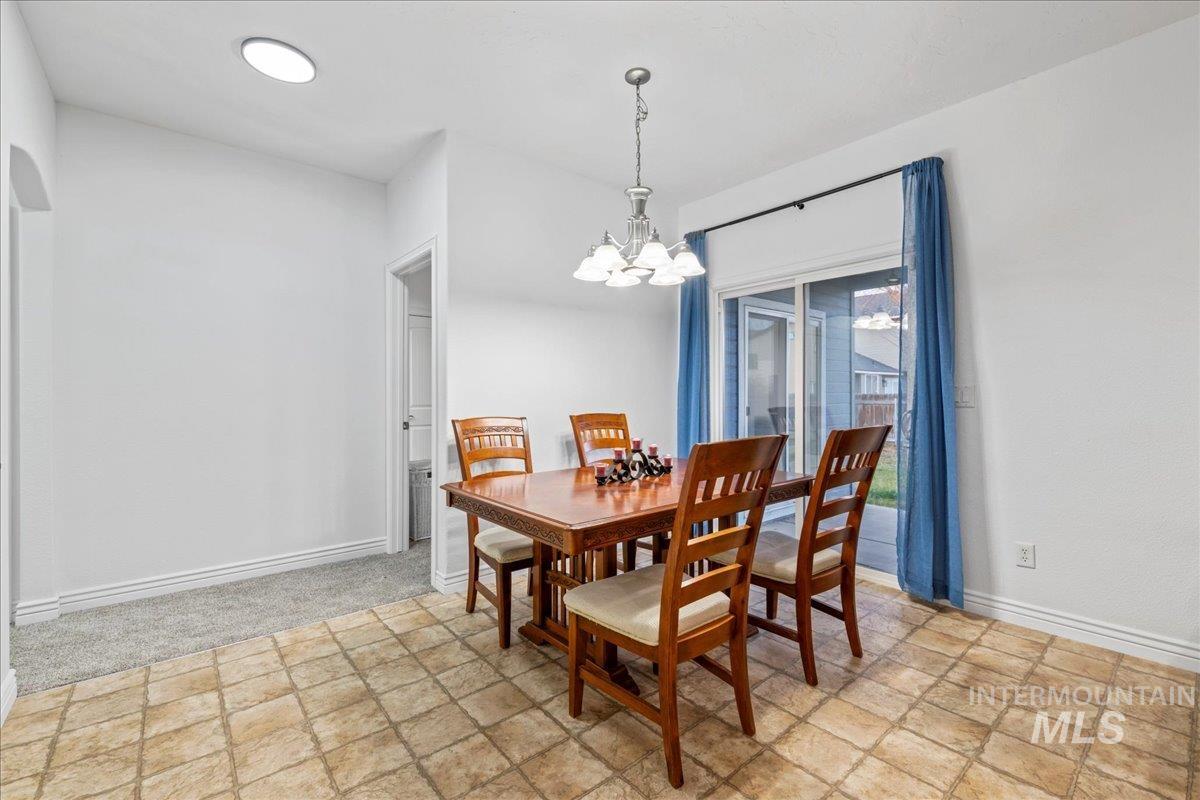 Dining room with a chandelier and stone finish flooring