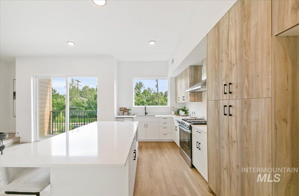 Kitchen featuring modern cabinets, plenty of natural light, gas range, light wood-style flooring, and recessed lighting