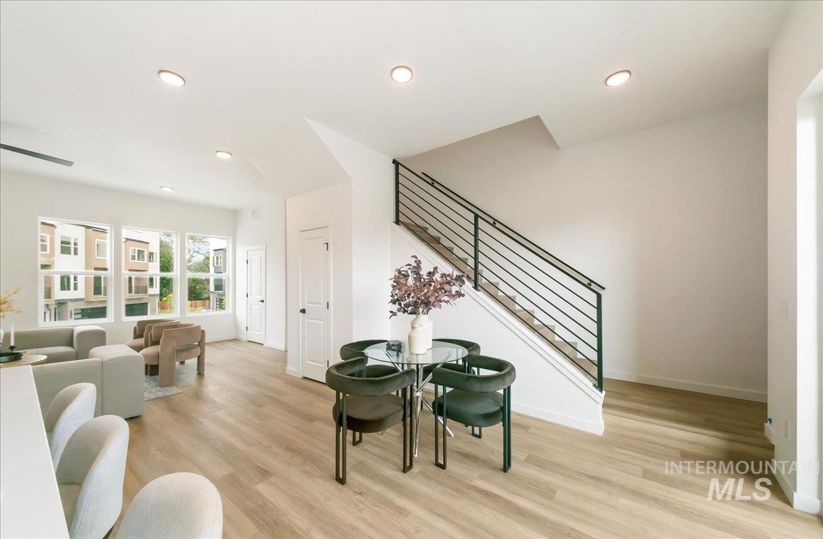 Living room with stairway, recessed lighting, and light wood-style floors