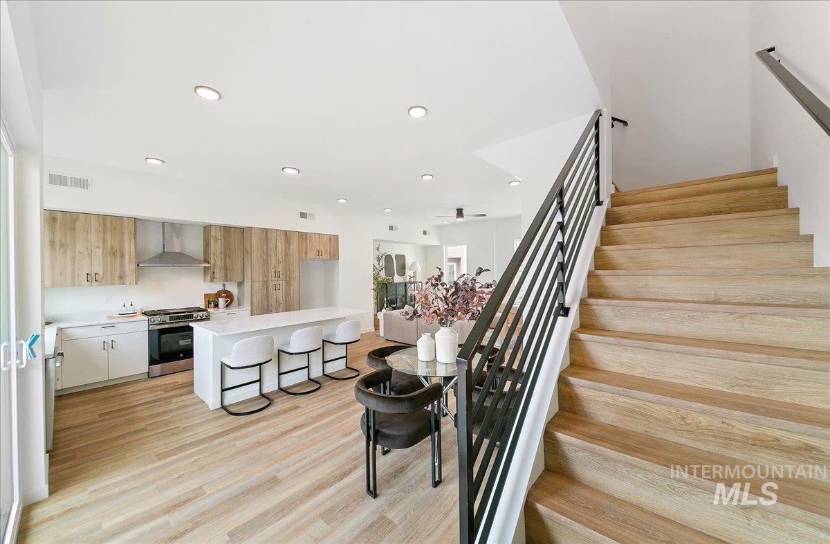 Stairs with wood finished floors and recessed lighting