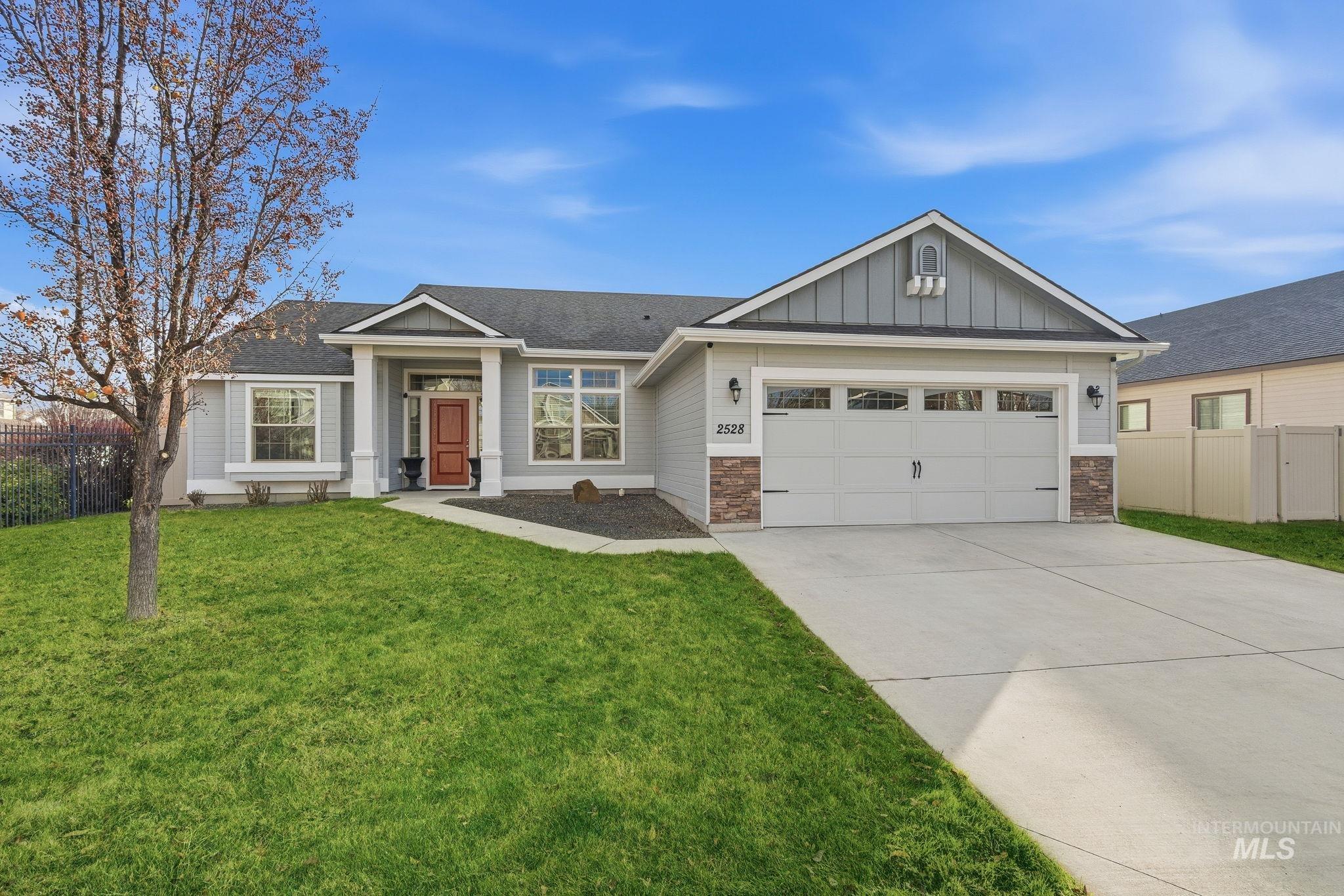 Craftsman-style home featuring board and batten siding, driveway, an attached garage, and a shingled roof