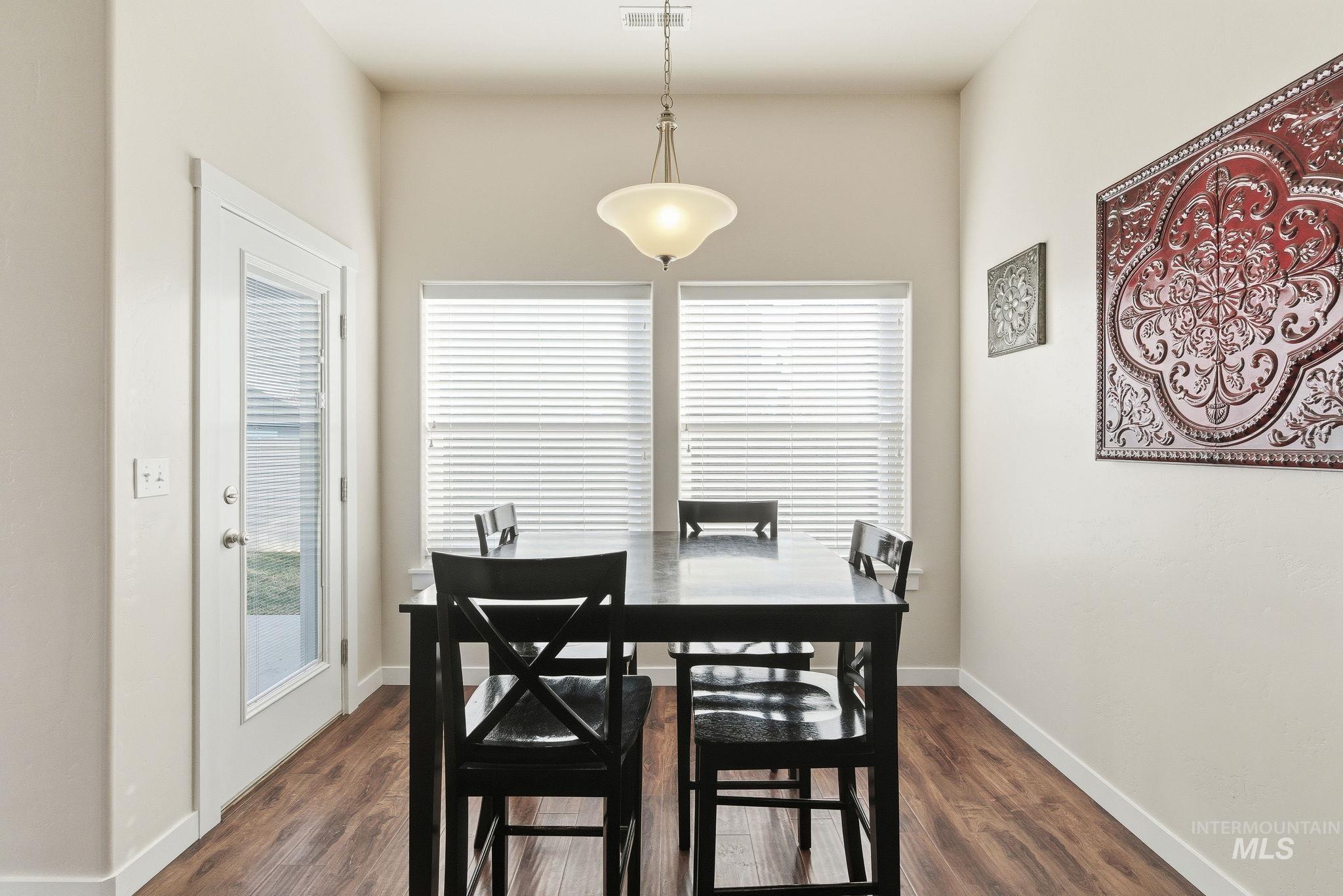 Dining area with plenty of natural light and dark wood-style flooring