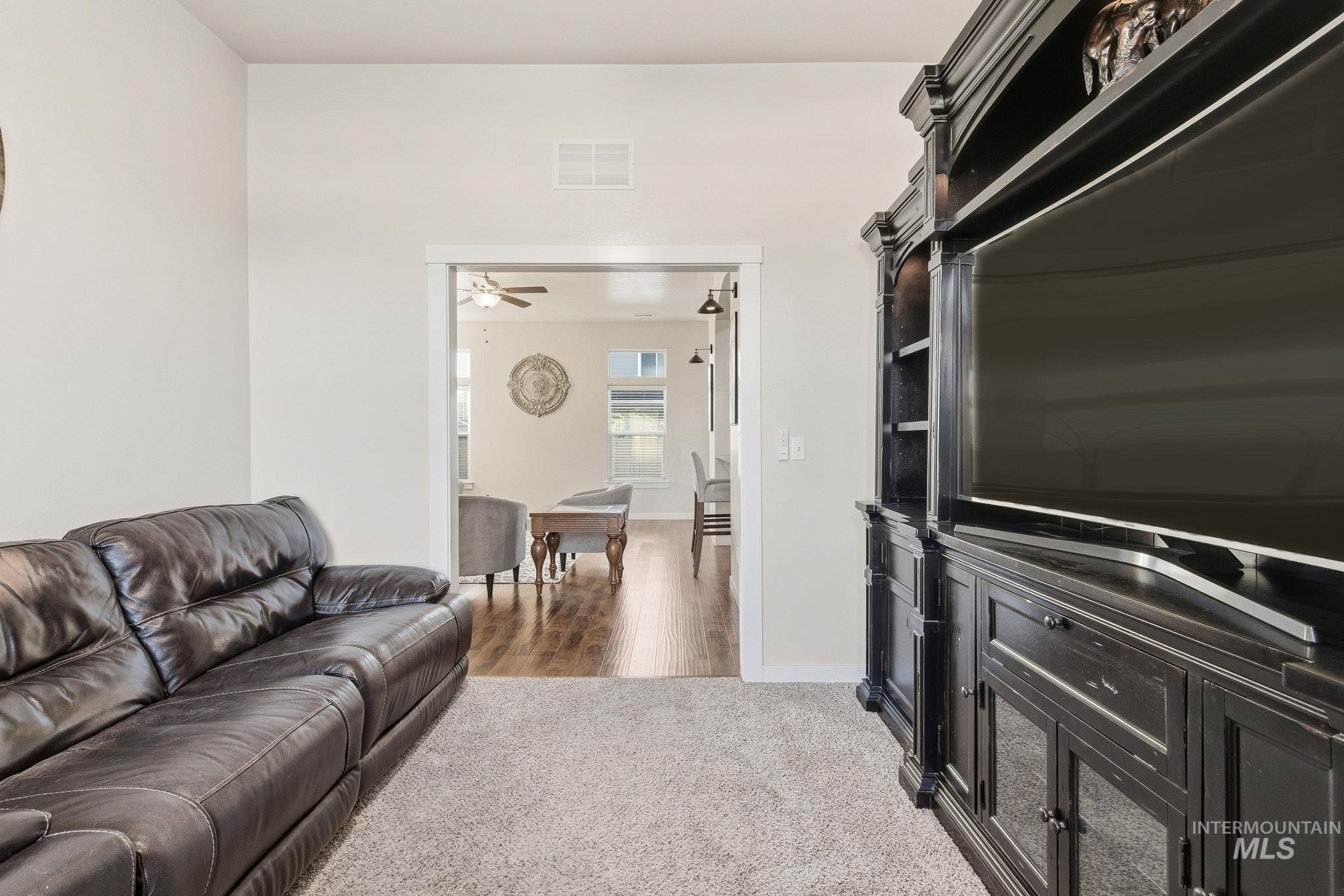 Living area featuring baseboards and light carpet